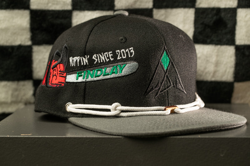 A black baseball cap with a gray brim and white strings, featuring embroidered text and graphics on the front.