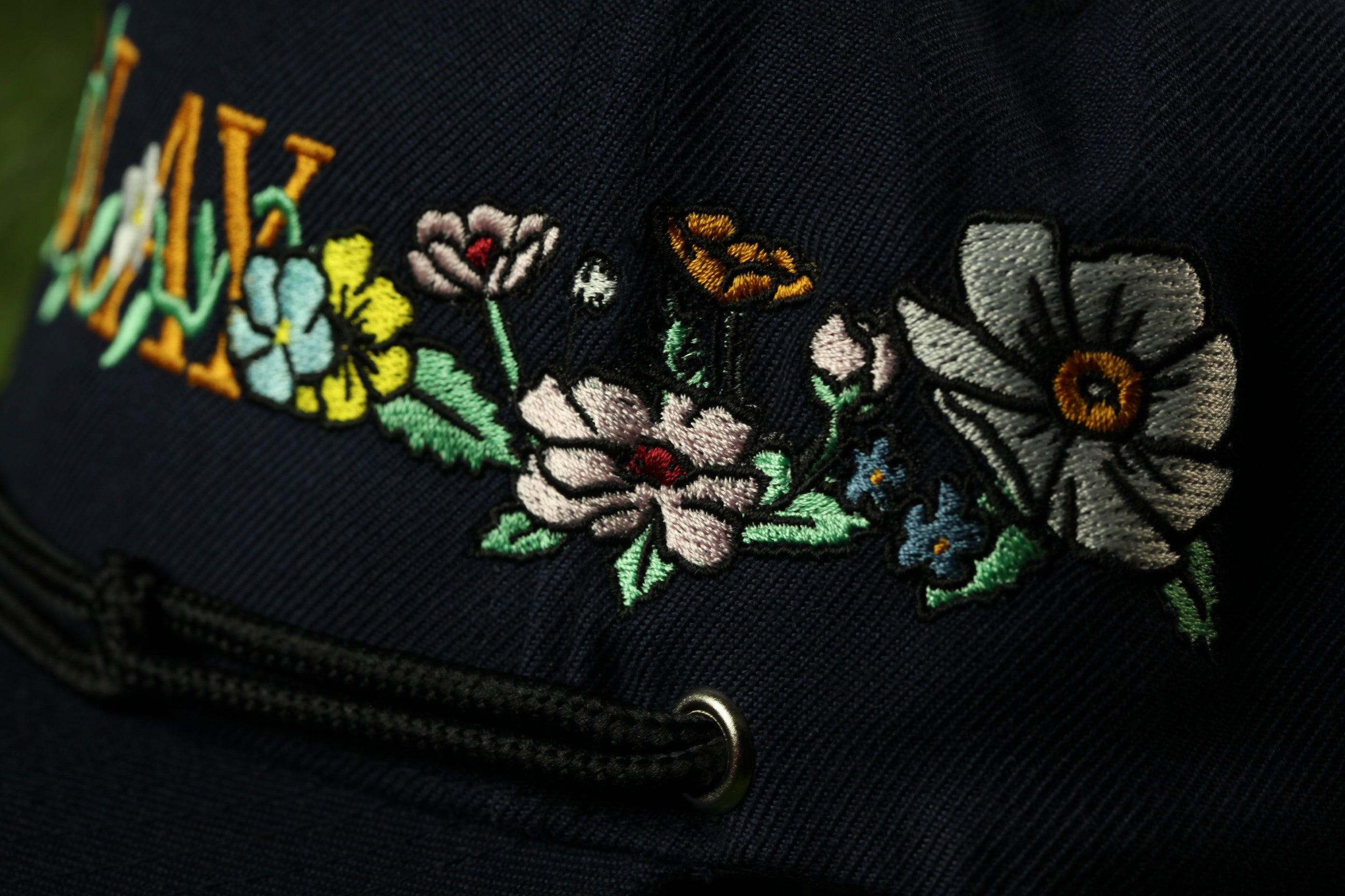 a close-up view of a dark fabric with a floral embroidered design on it.