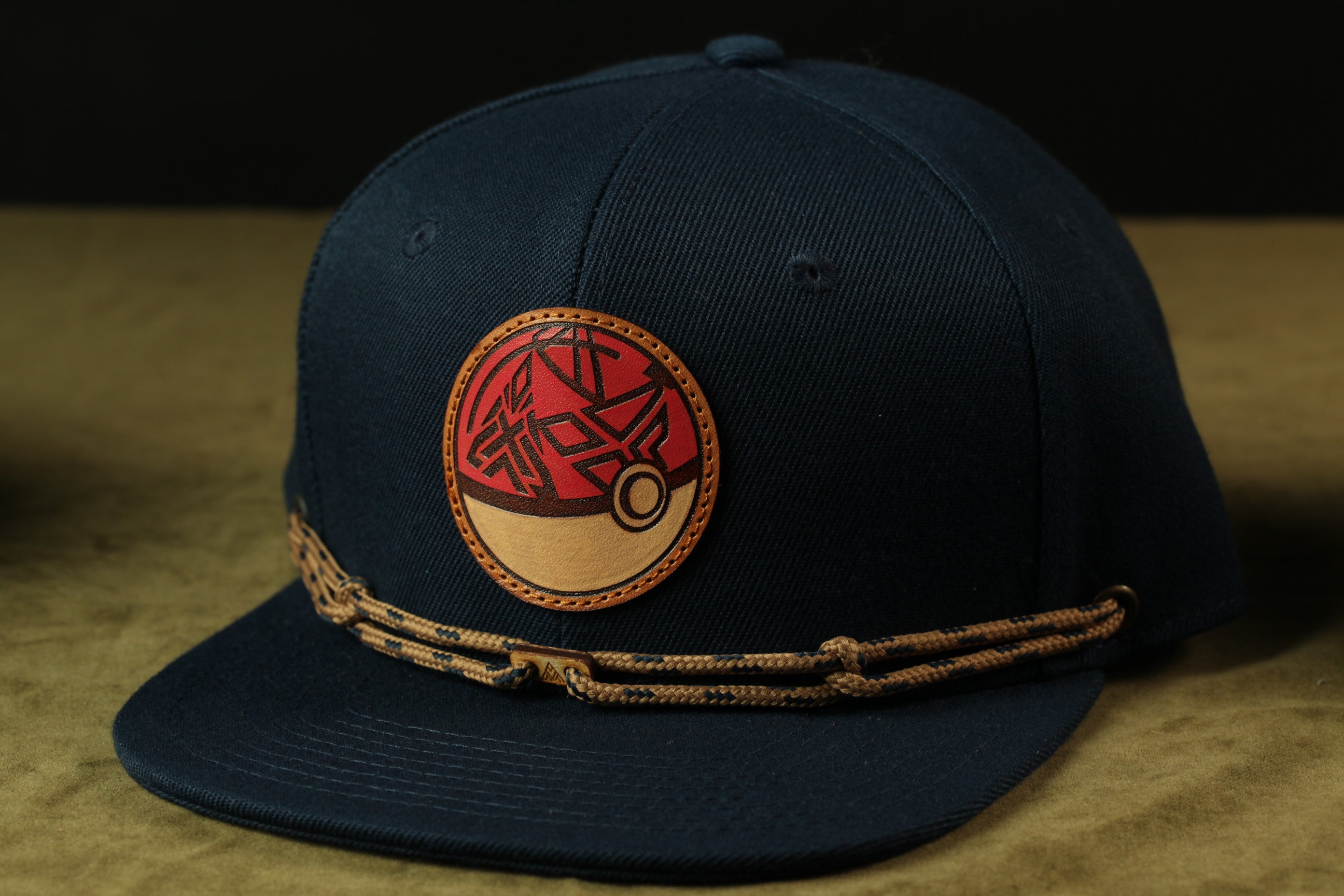 A navy blue baseball cap with a red and orange circular logo on the front.