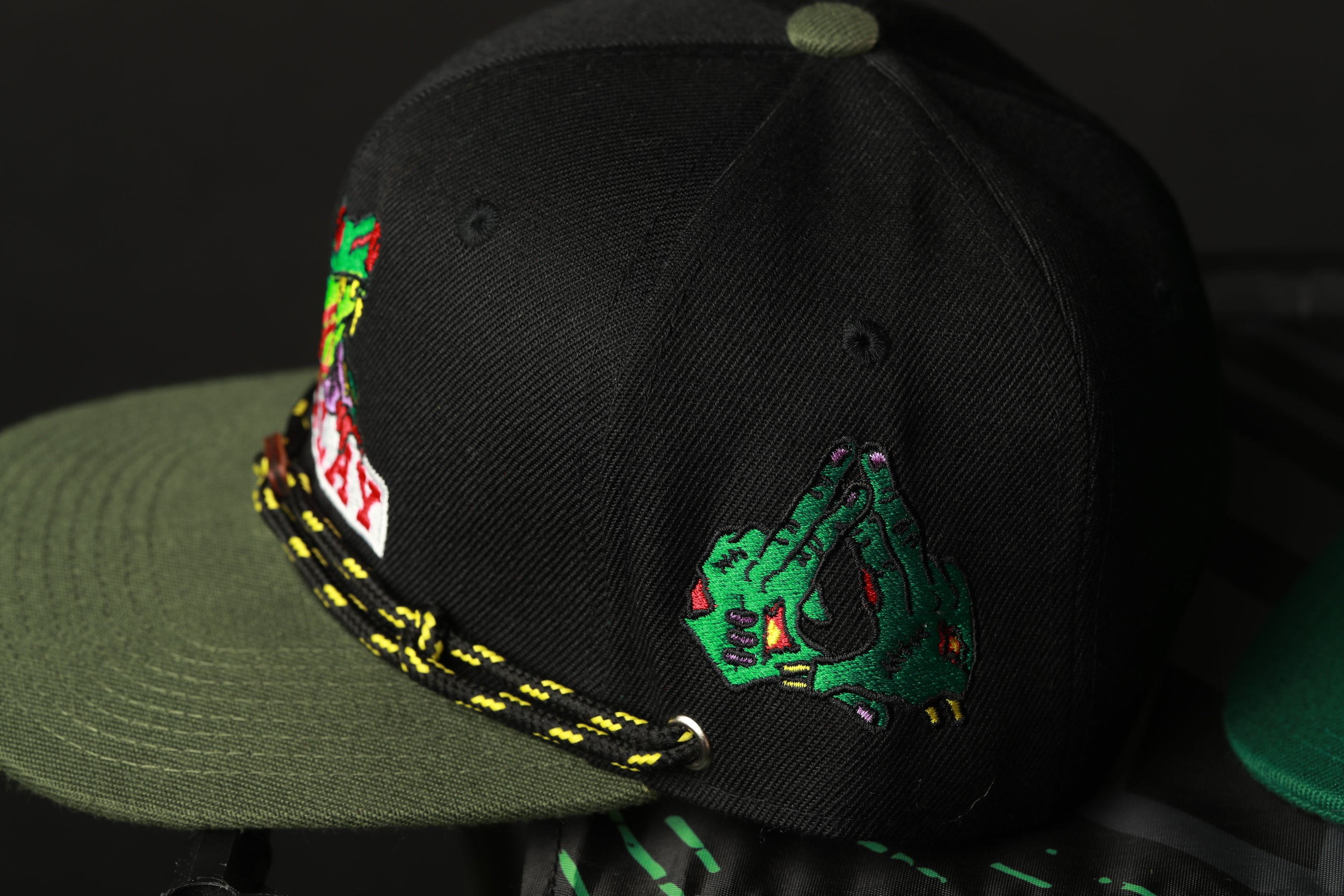 A black baseball cap with colorful embroidered designs on the front.