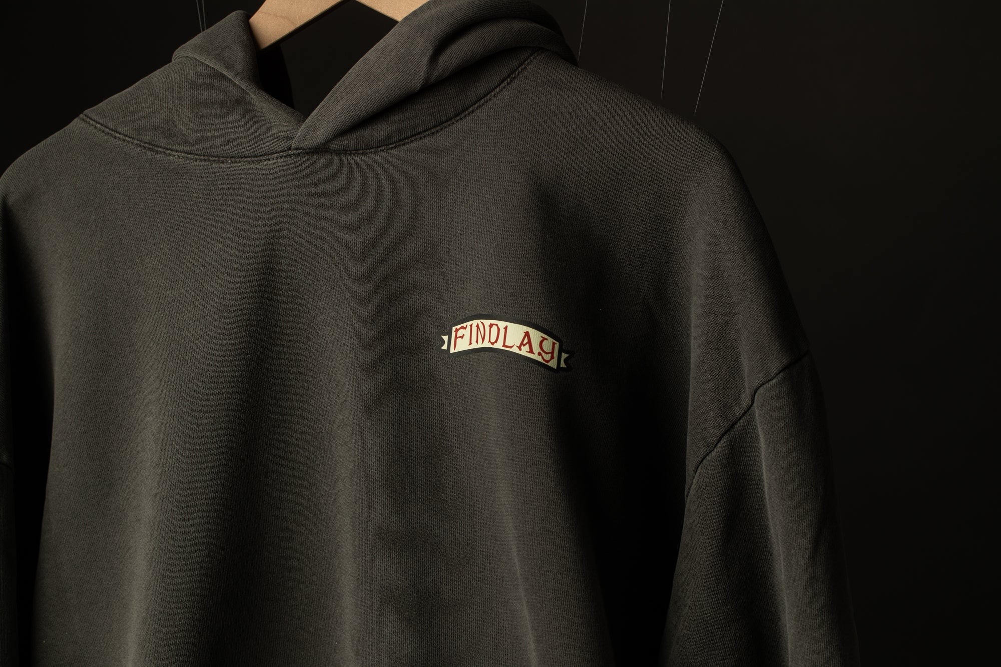 A dark grey hoodie with a small white logo on the front.