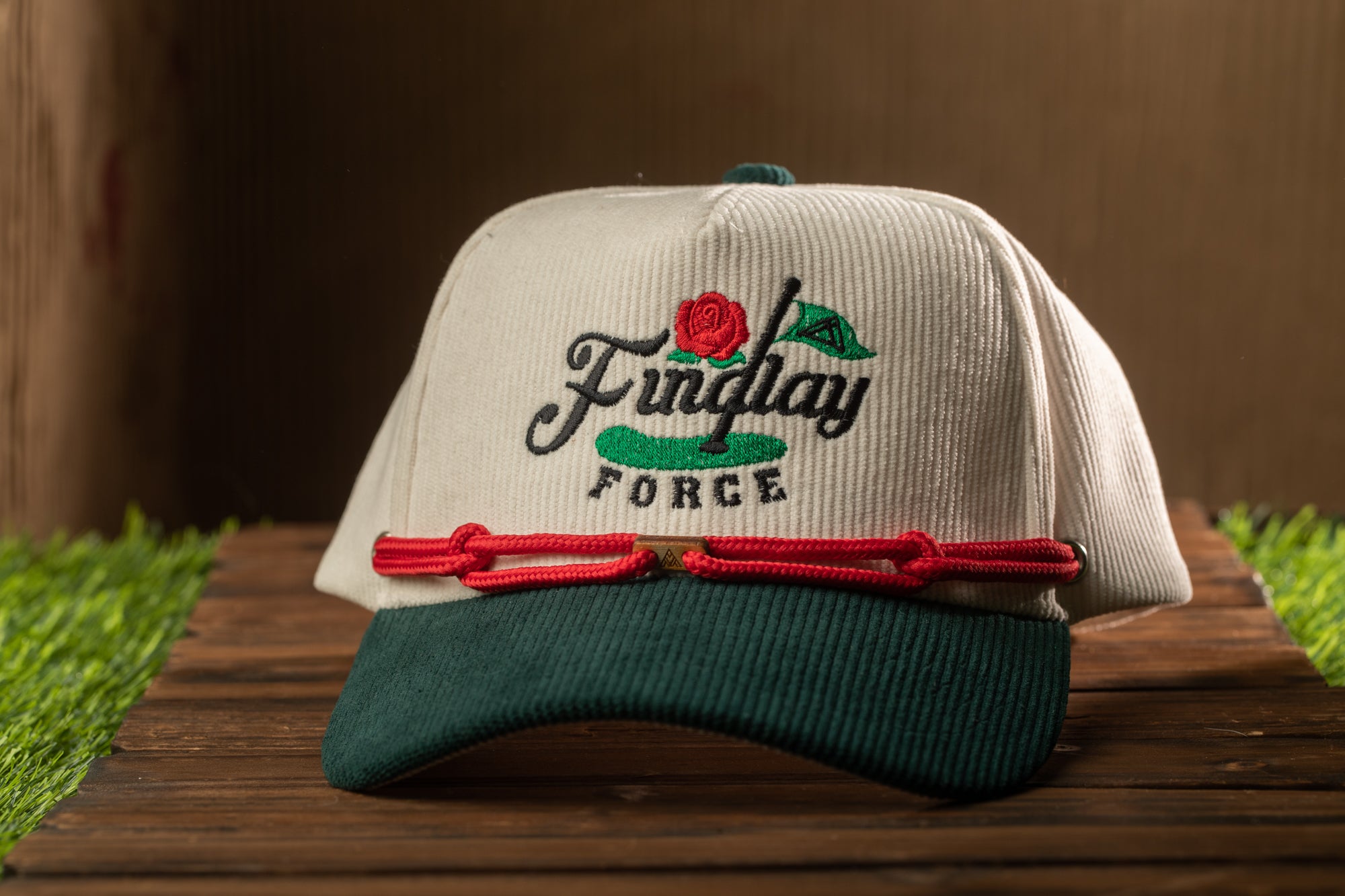 A white baseball cap with a green brim and red string, featuring the text "Findlay Force" on the front.