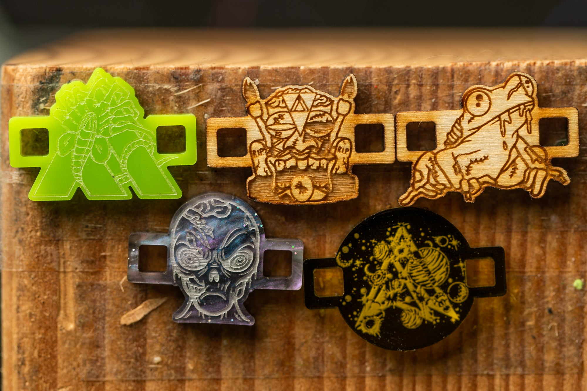 a collection of five distinct wooden objects, each with unique designs and patterns, displayed on a wooden surface.