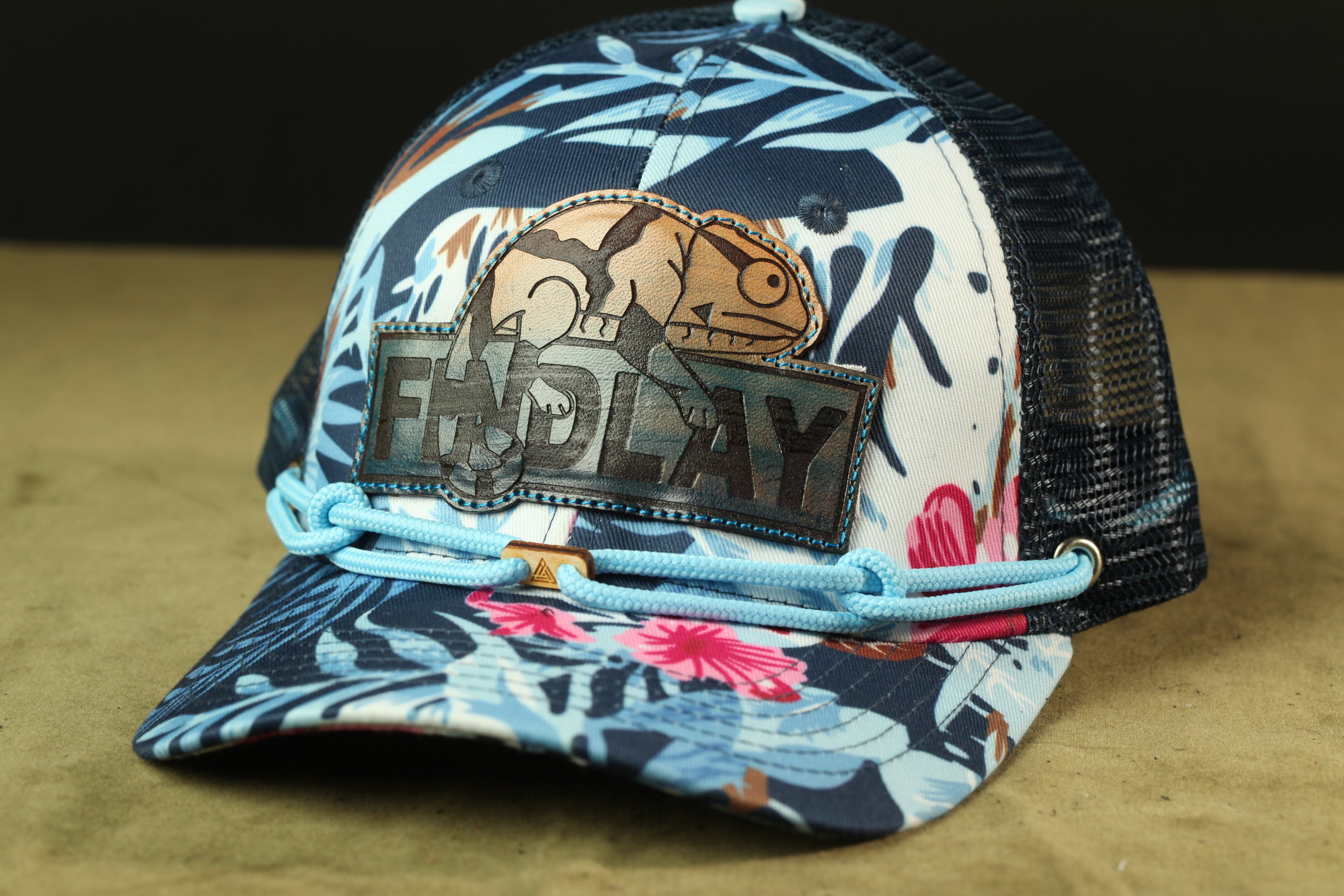 A colorful baseball cap with a floral pattern and a patch featuring a cartoon character.