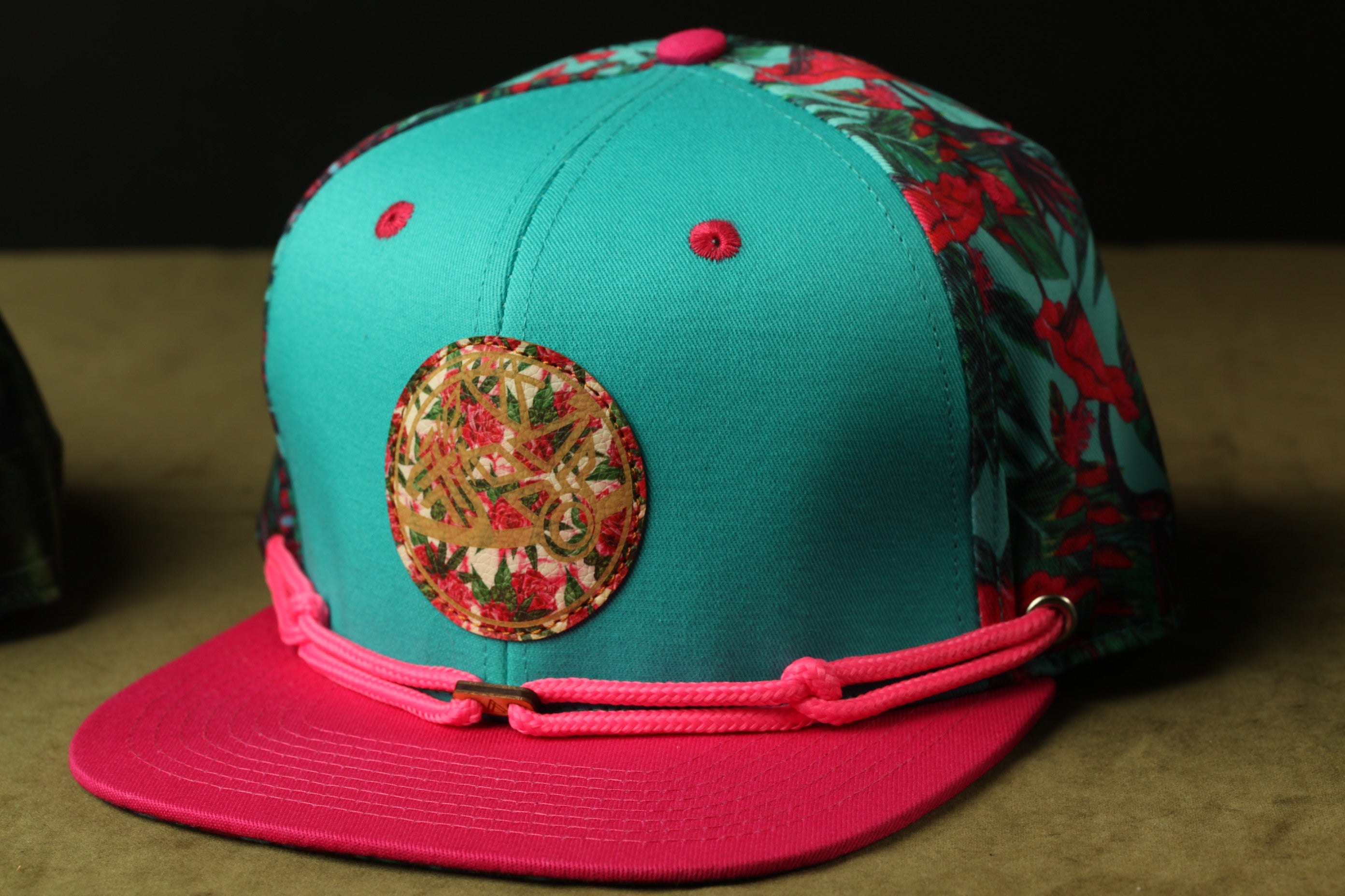 A colorful baseball cap with a floral pattern and a circular patch on the front.