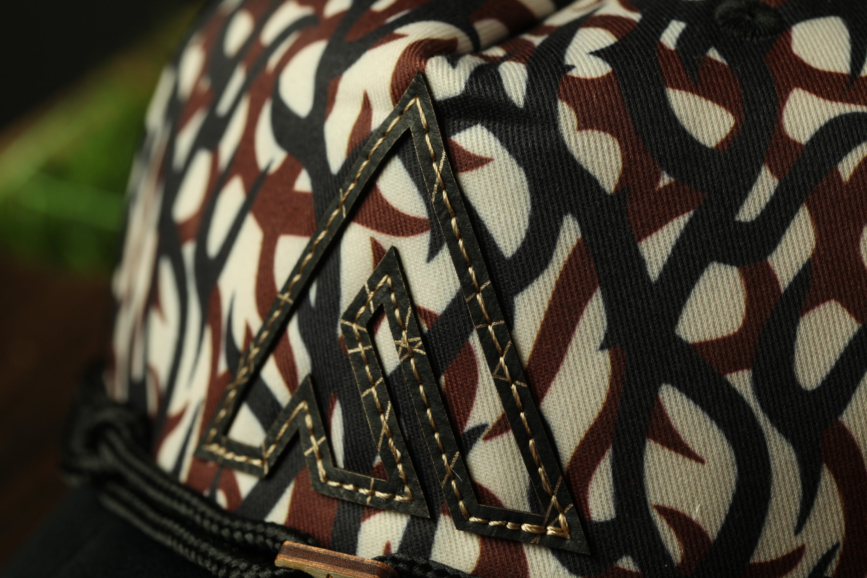 A close-up view of a patterned fabric with a distinctive triangular logo or emblem on it.