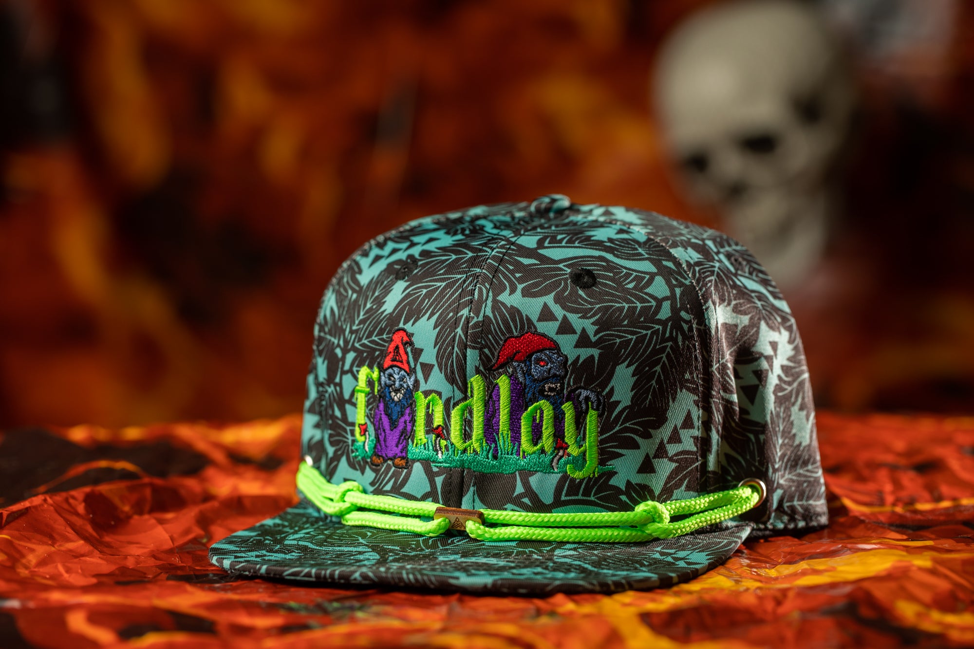 A colorful baseball cap with a patterned design and the word "FINDAY" printed on it, placed on a surface with a blurred background.