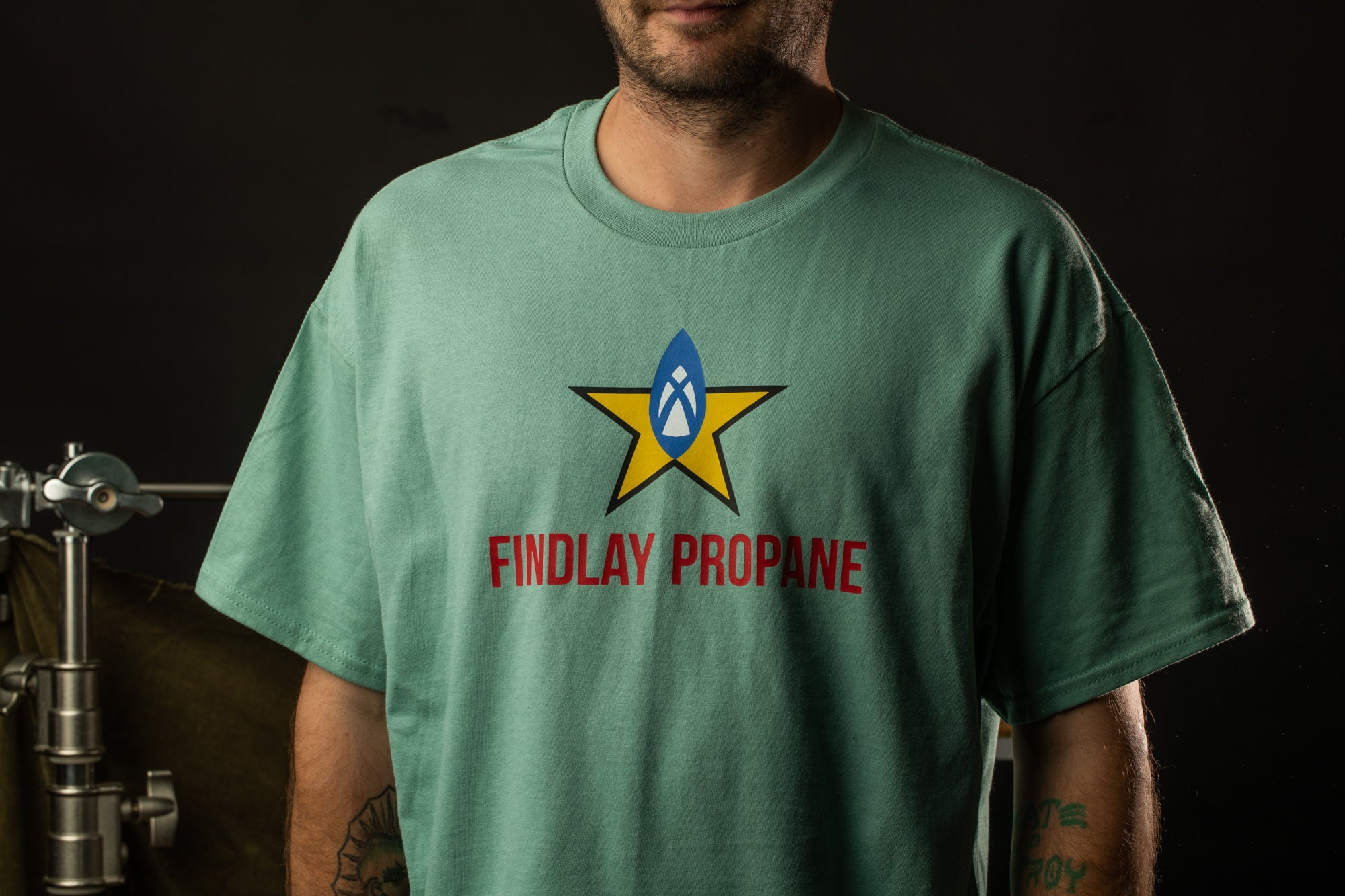 A man wearing a green t-shirt with a graphic design and text on it.