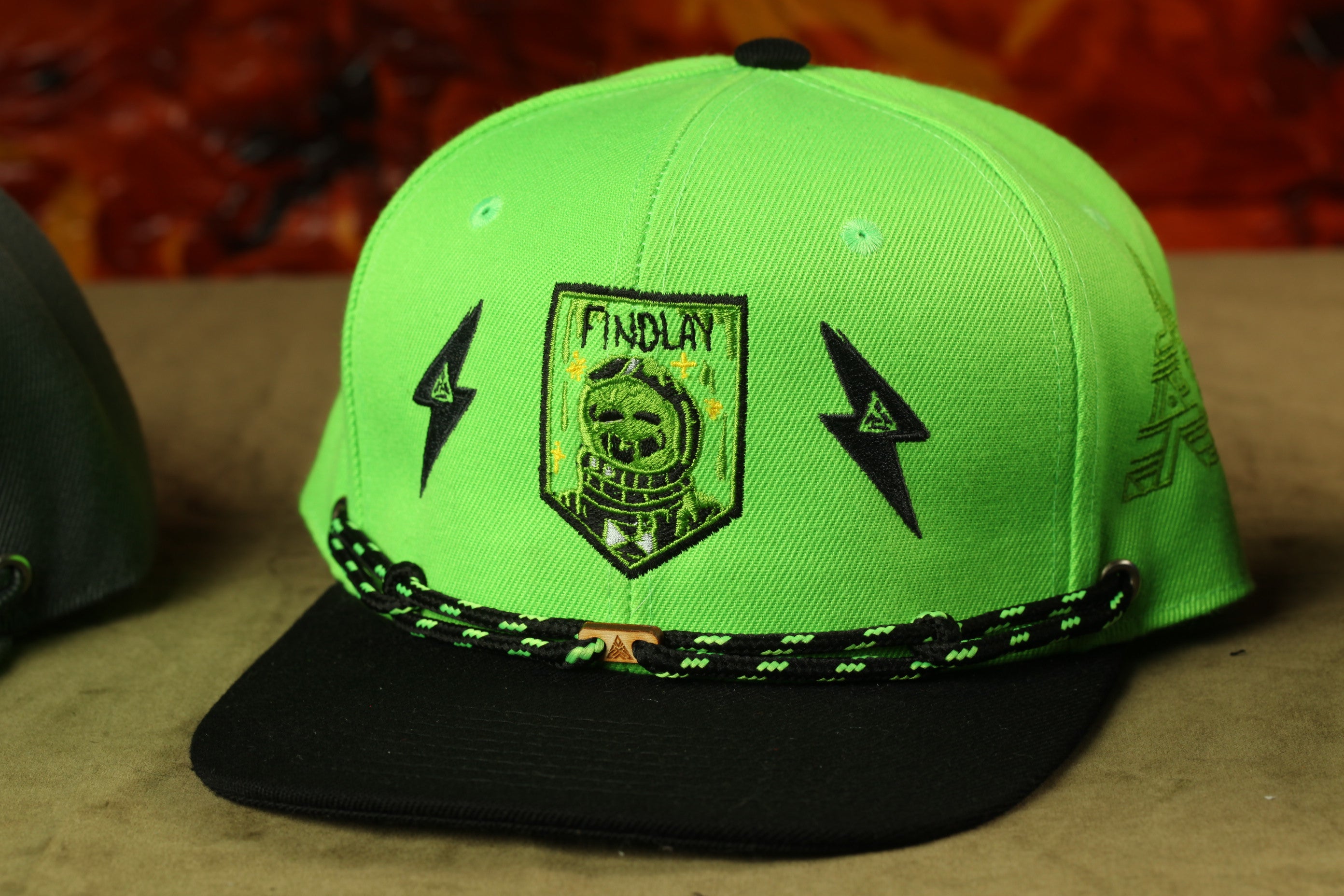 A neon green baseball cap with a black brim and a black and green braided strap.