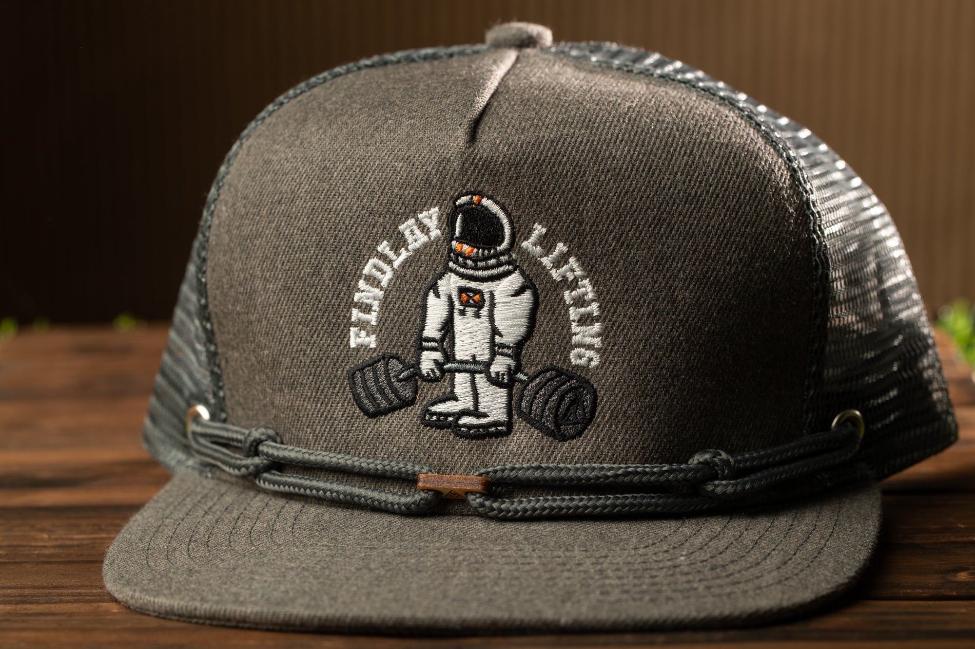 A gray baseball cap with a black mesh panel and a white embroidered logo on the front.