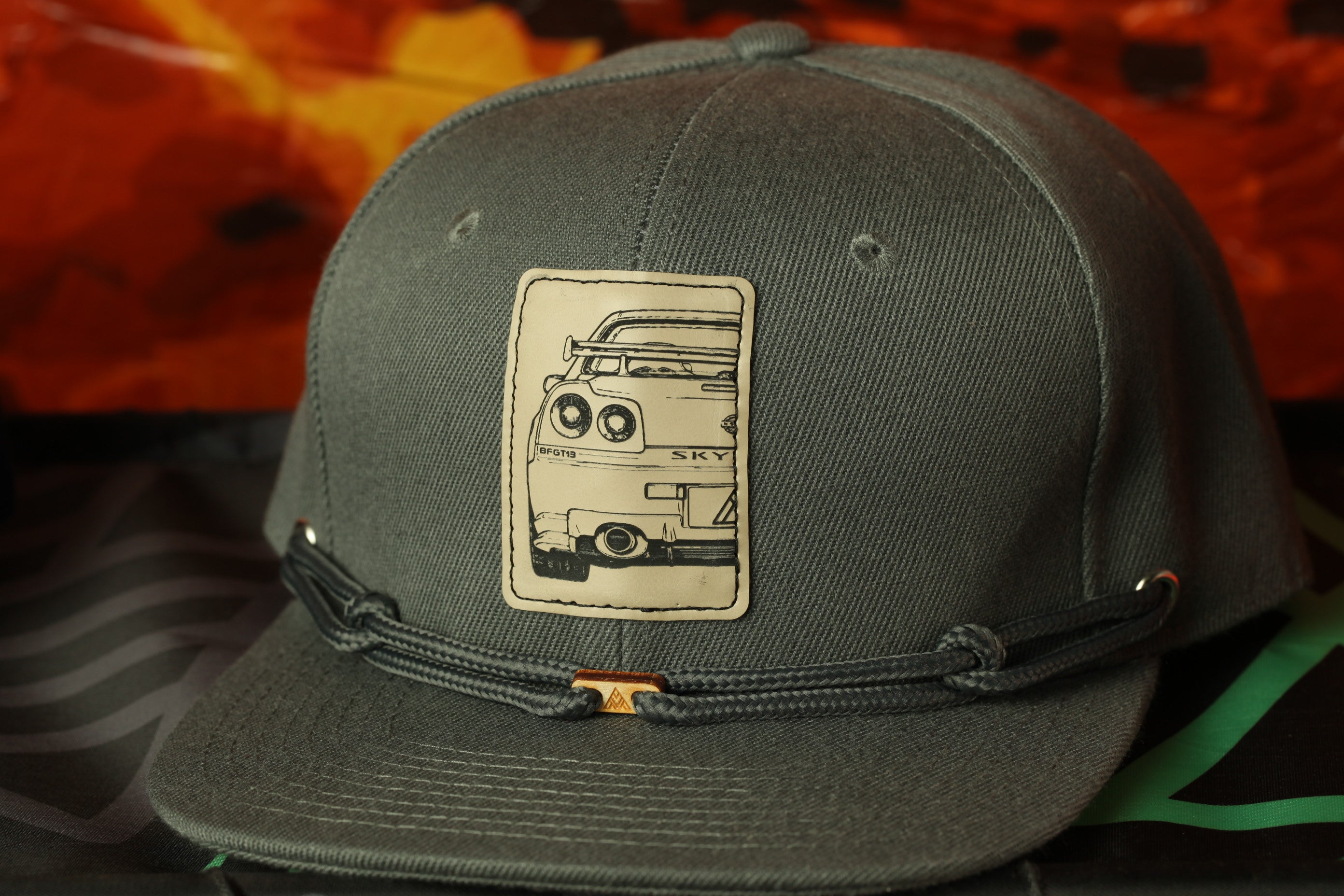 A gray baseball cap with a graphic of a car on the front.
