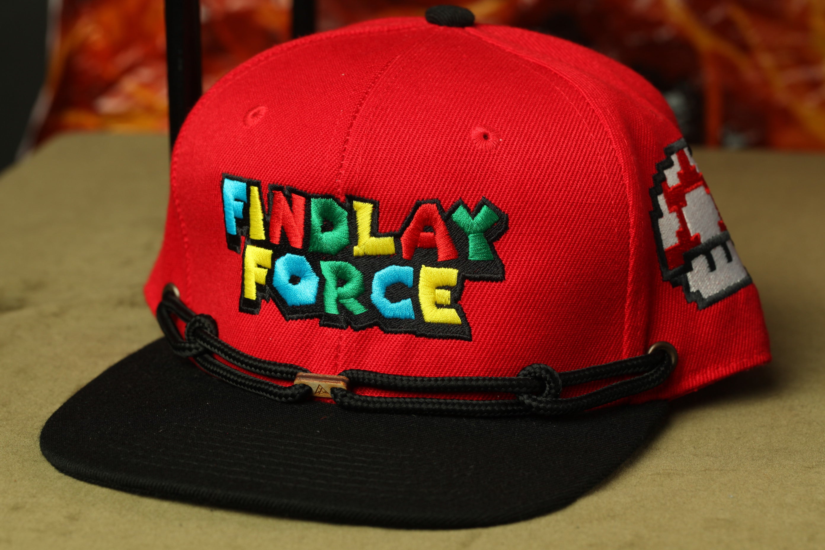 A red baseball cap with the text "FINDLAY FORCE" printed on it.