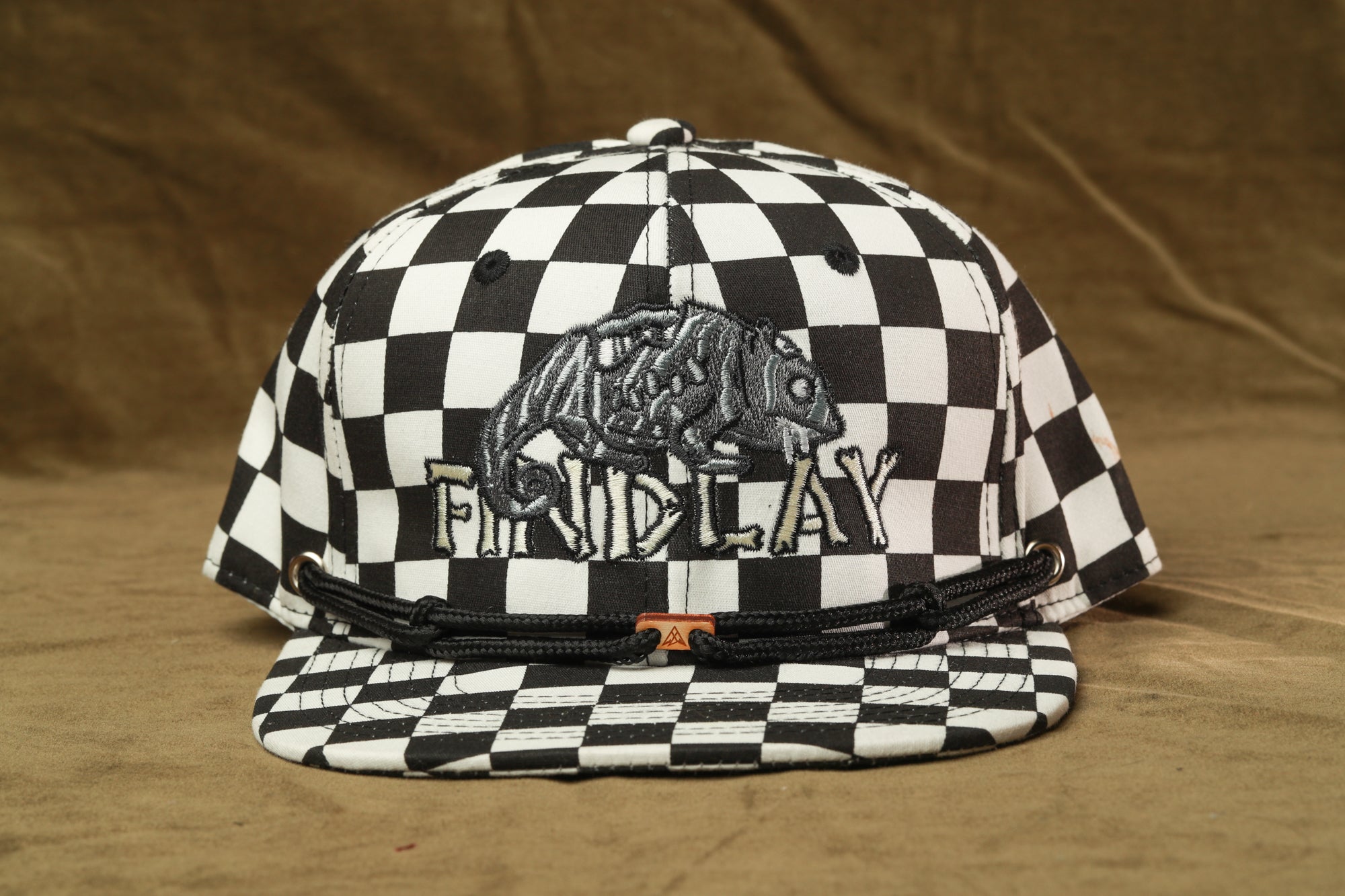 A black and white checkered baseball cap with a graphic of a bear on the front.