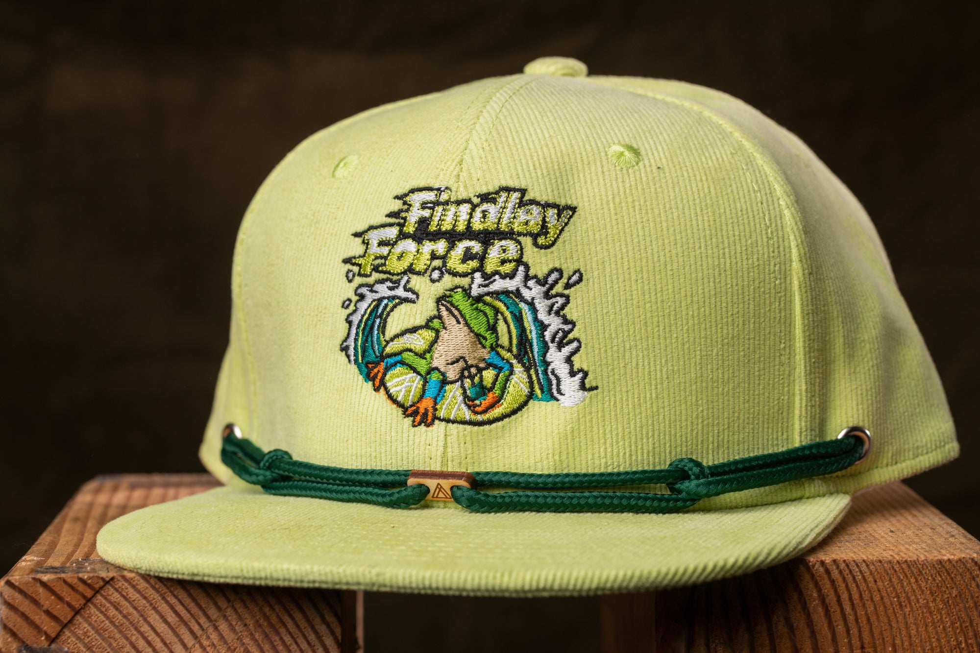 A yellow baseball cap with a green strap and a logo on the front.