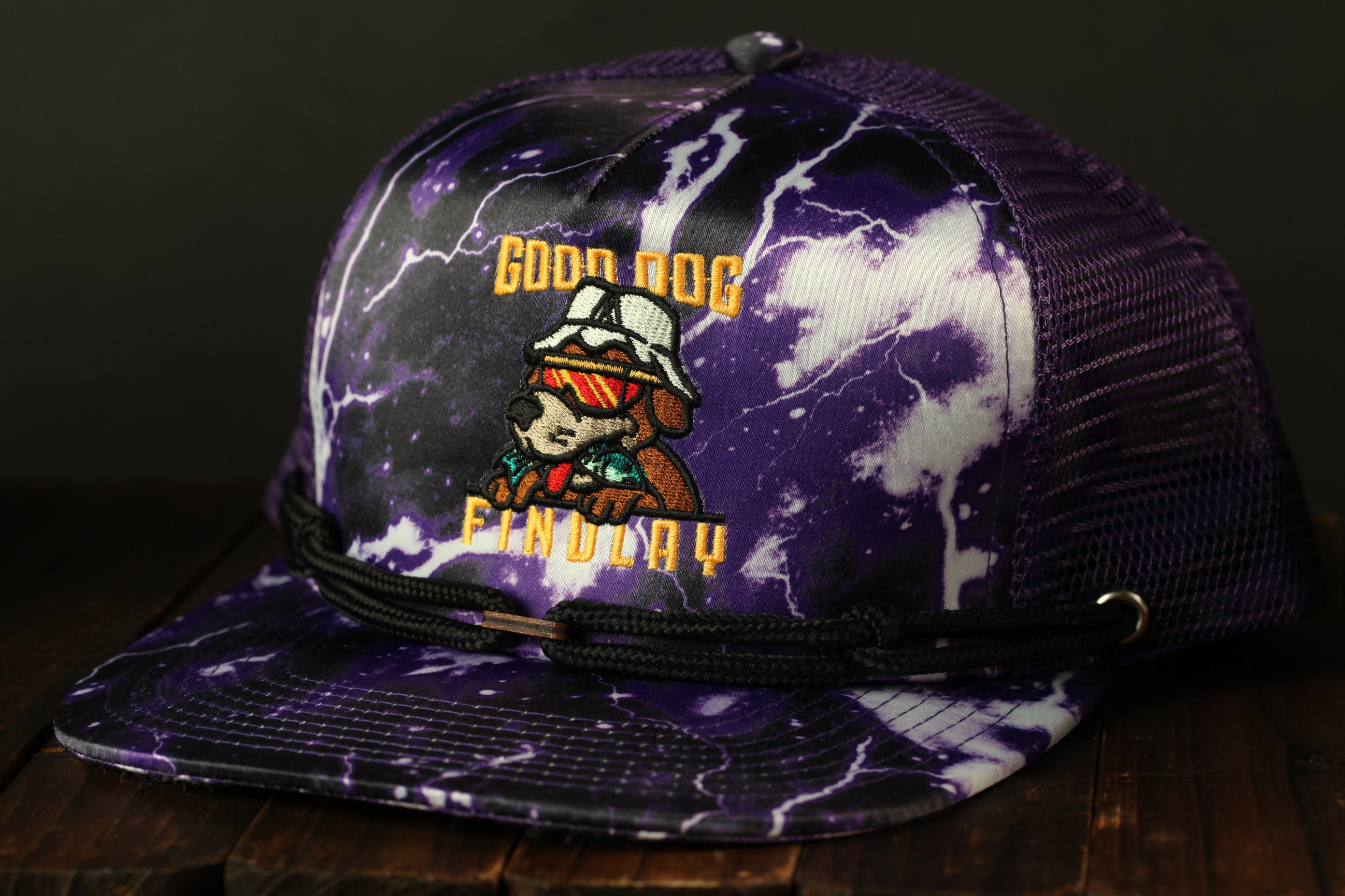 A purple baseball cap with a graphic design featuring a cartoon dog wearing a white hat and sunglasses, along with the text "GOOD OCC FIND A DAY" printed on it.