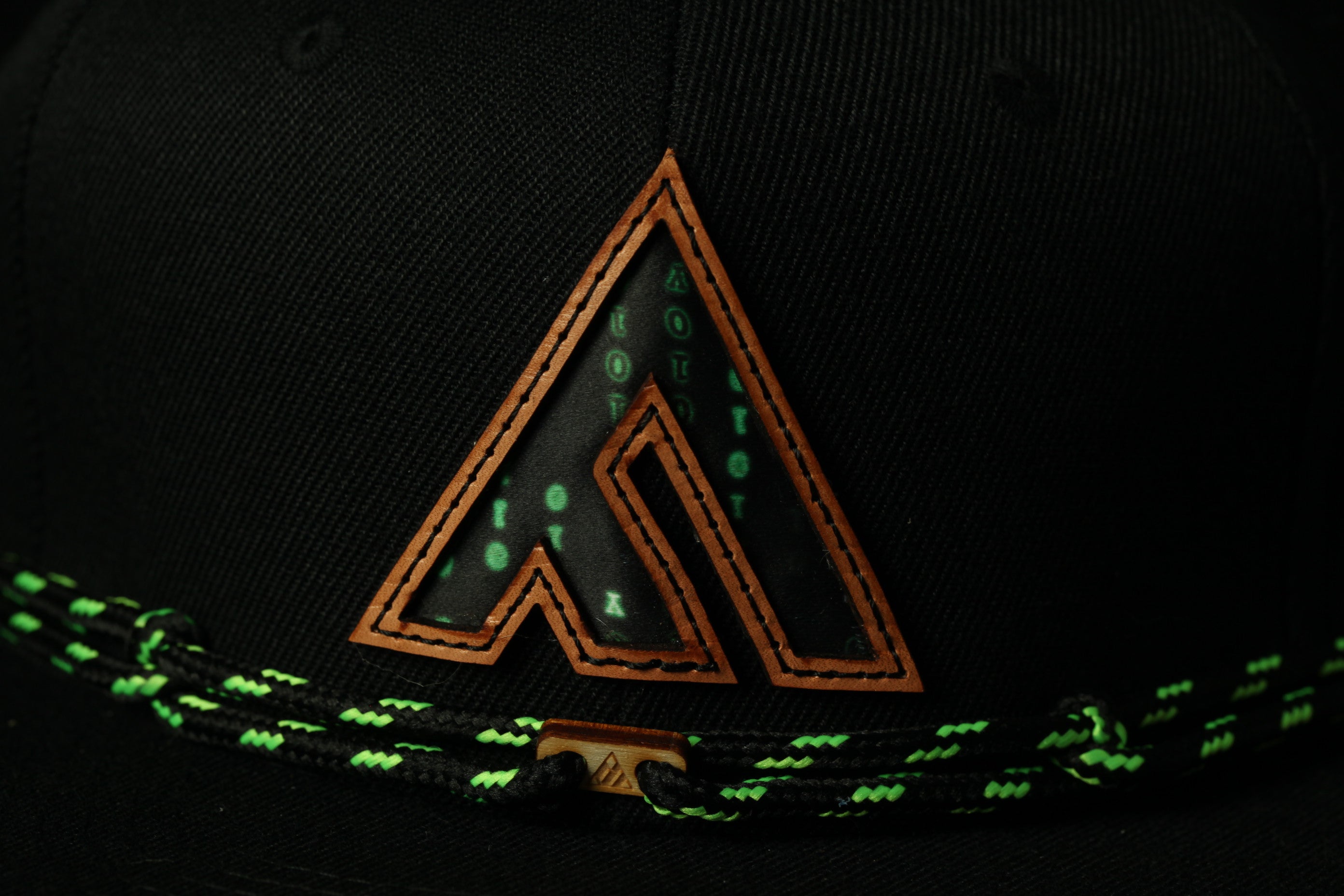 A close-up view of a black baseball cap with a distinctive logo on the front.