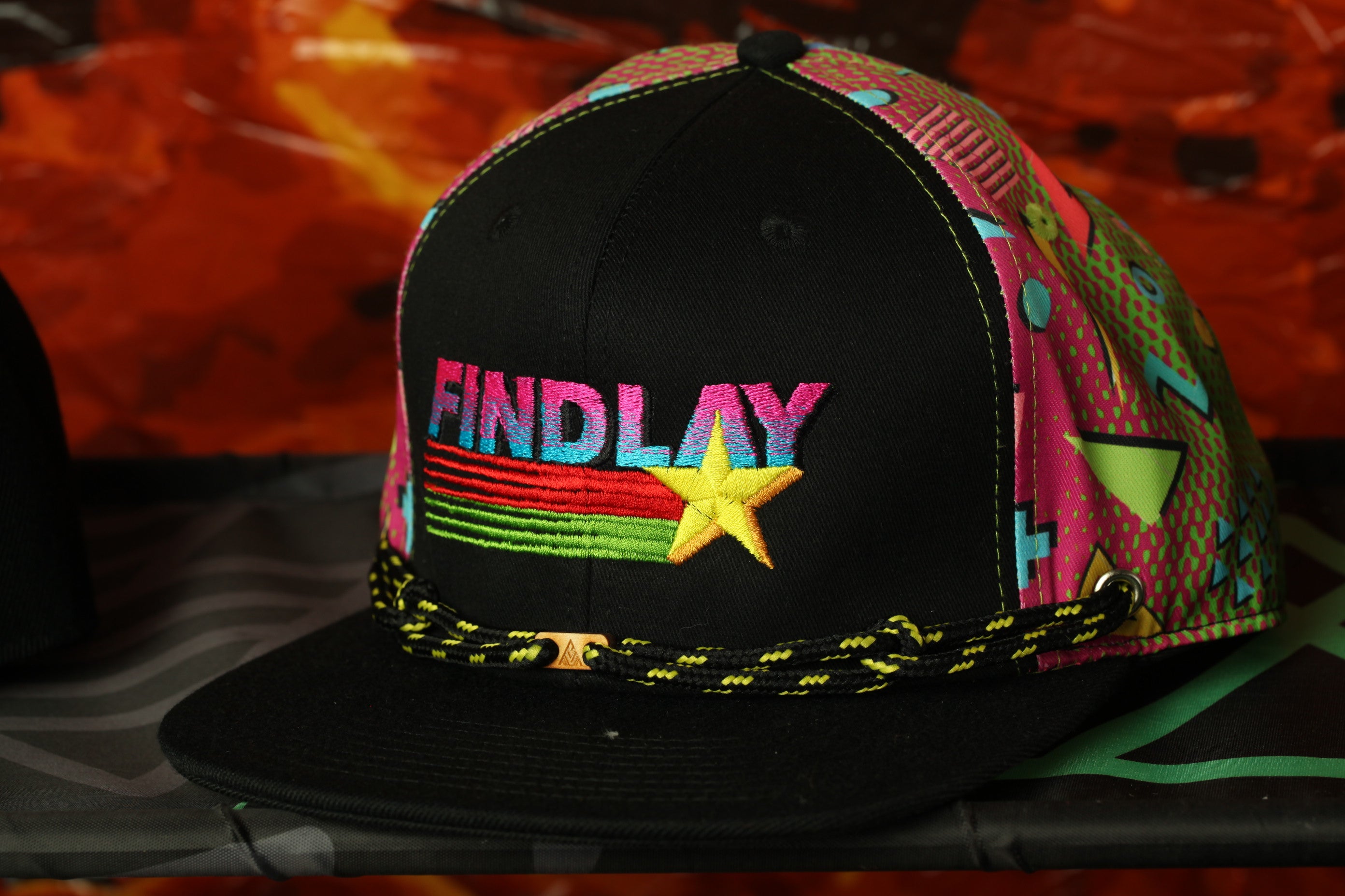 A black baseball cap with a colorful, patterned design and the word "FINDlay" printed on it.