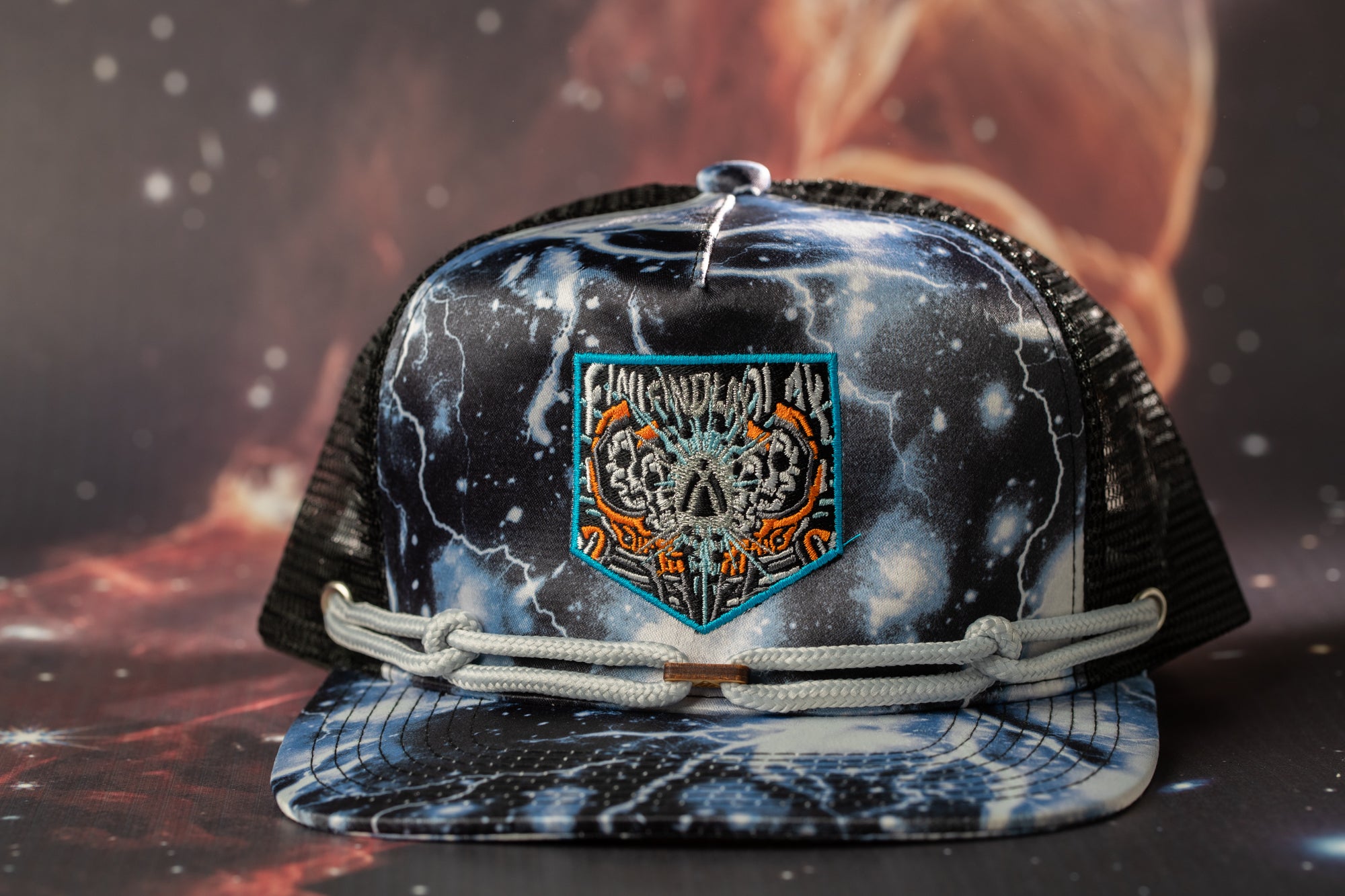 A black and white baseball cap with a colorful, abstract design on the front, featuring a central patch with a skull and lightning bolt motif.