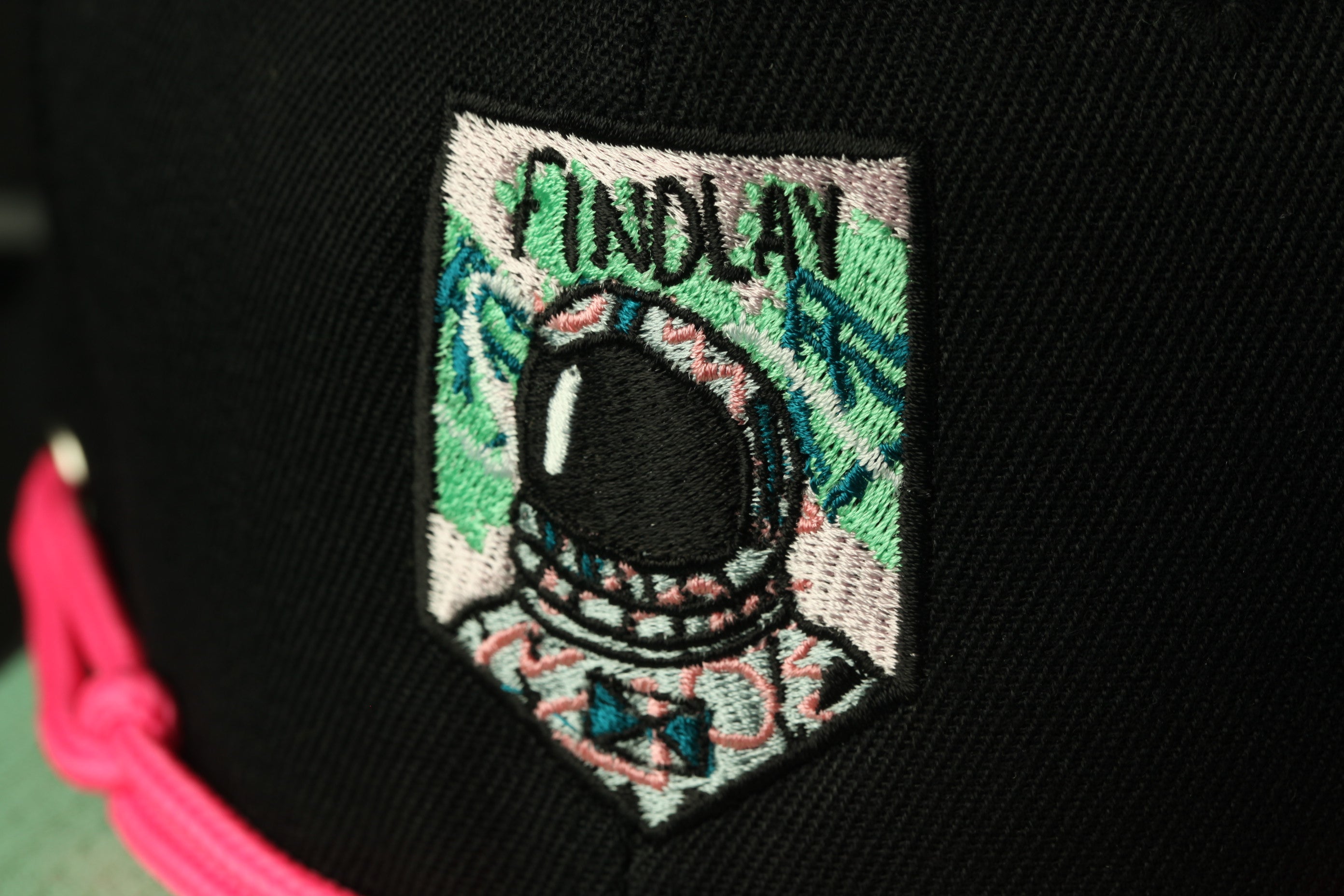 a close-up of a black baseball cap with a colorful patch on the front.