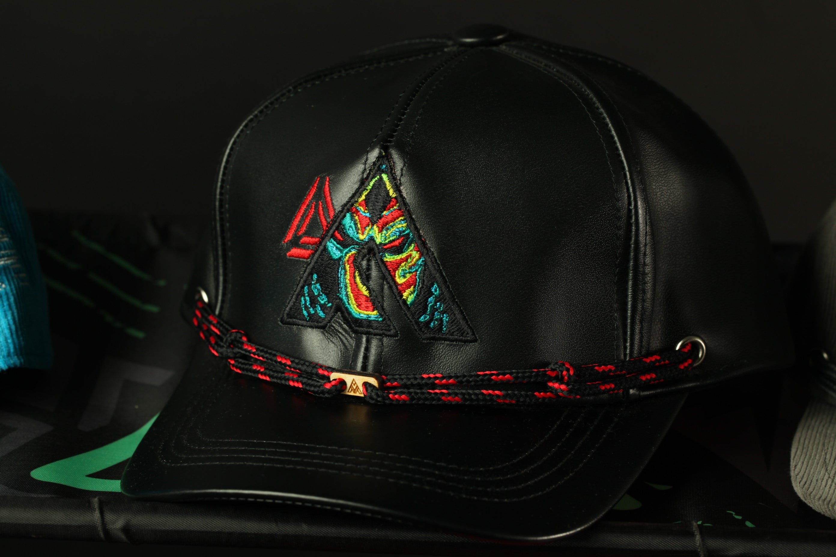 A black baseball cap with a colorful, embroidered logo on the front.