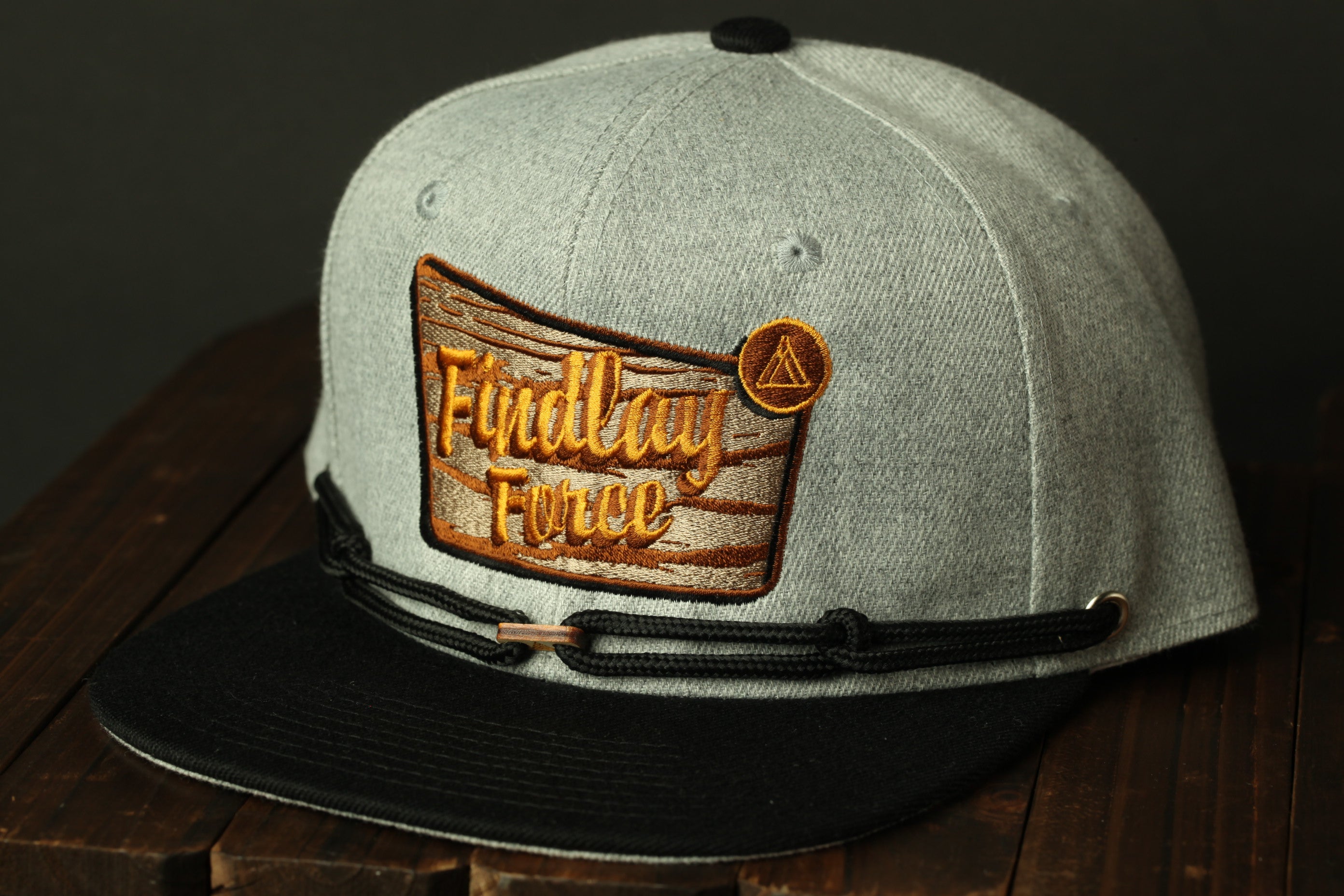 A gray baseball cap with a black brim and a patch on the front displaying the text "Findlay Force".