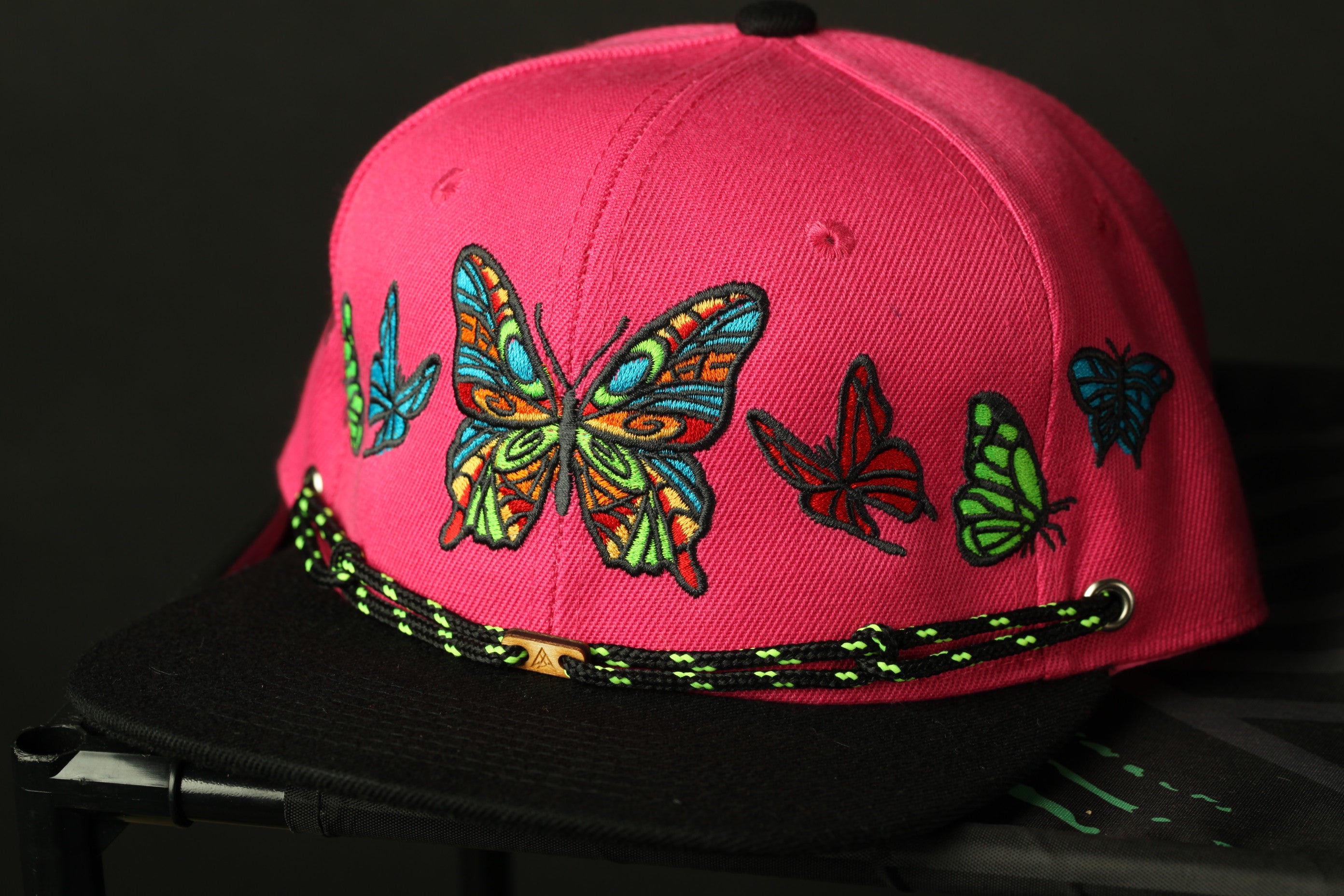 A pink baseball cap with colorful butterfly embroidery on the front.