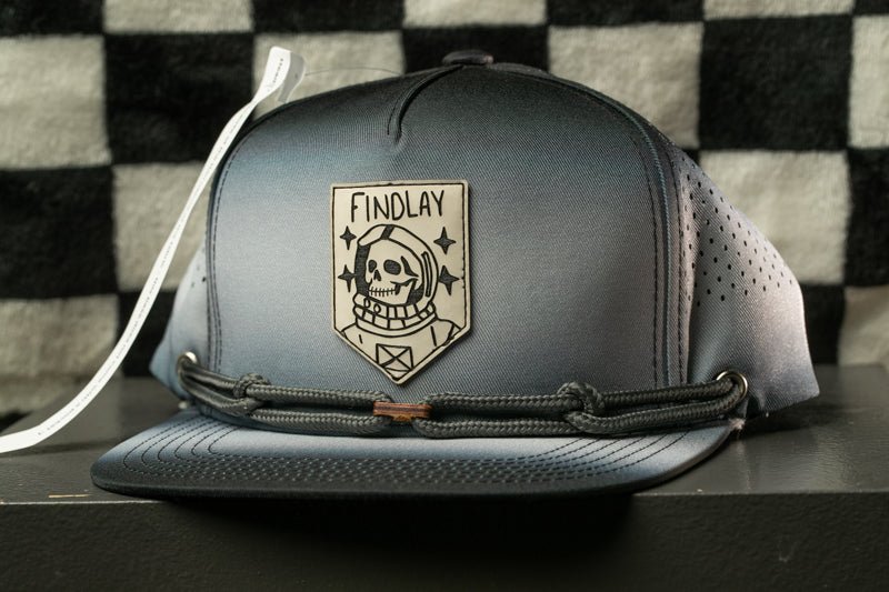 A black baseball cap with a skull and crossbones design on the front, featuring a text patch that says "FINDLAY".