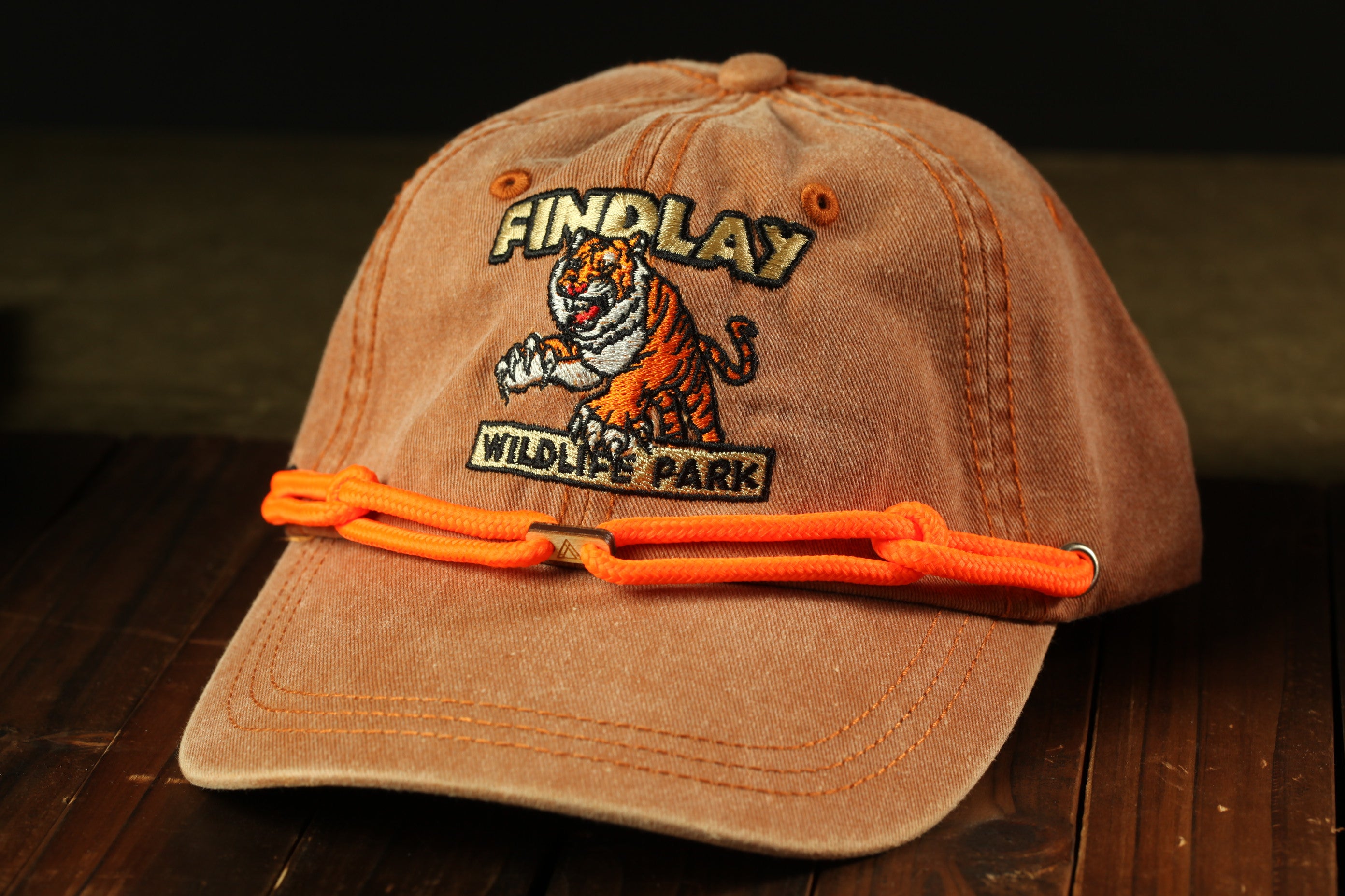 A brown baseball cap with an embroidered tiger and the text "FIND LAY WILDLIFE PARK" printed on it.