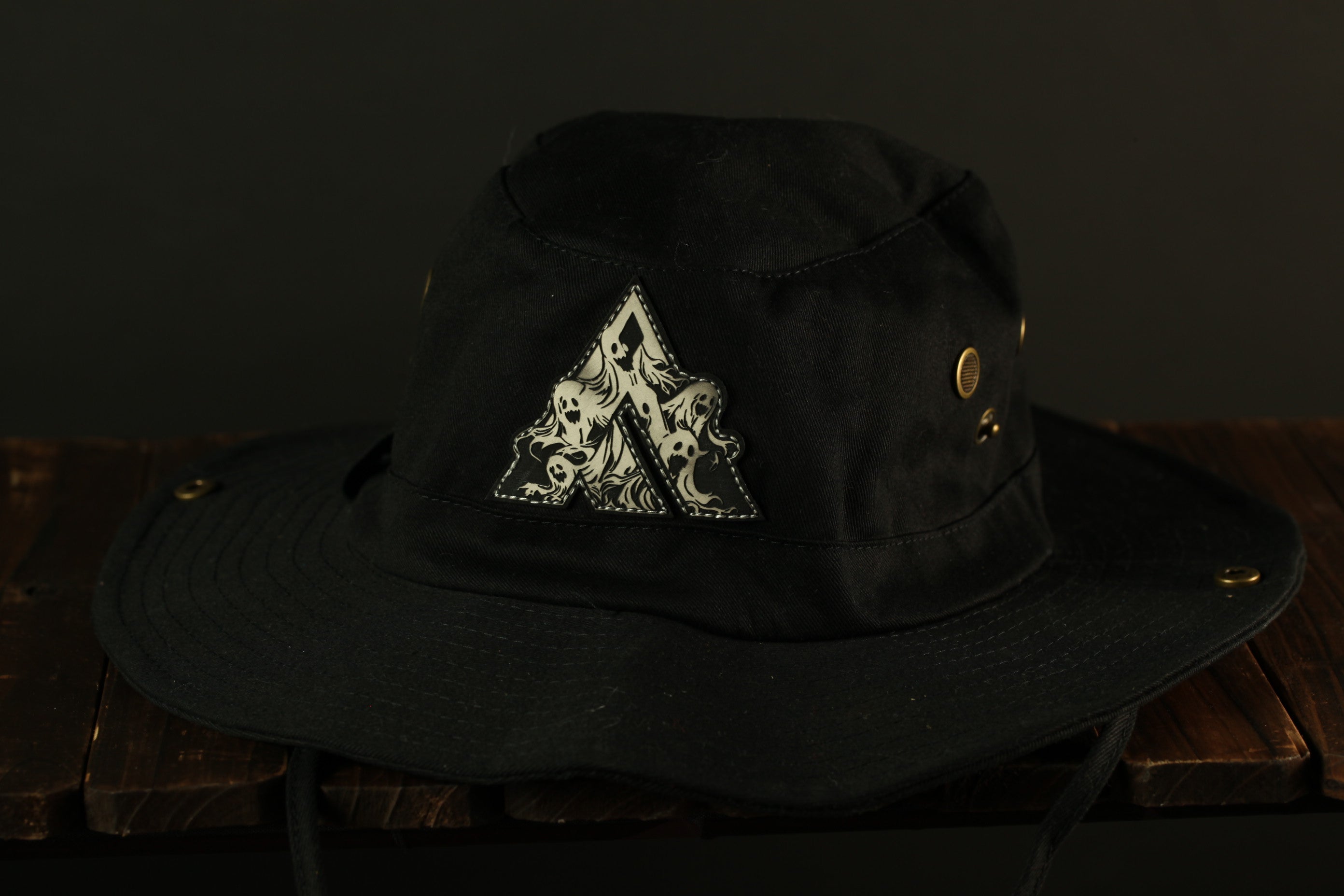 A black bucket hat with a white triangular design on the front.