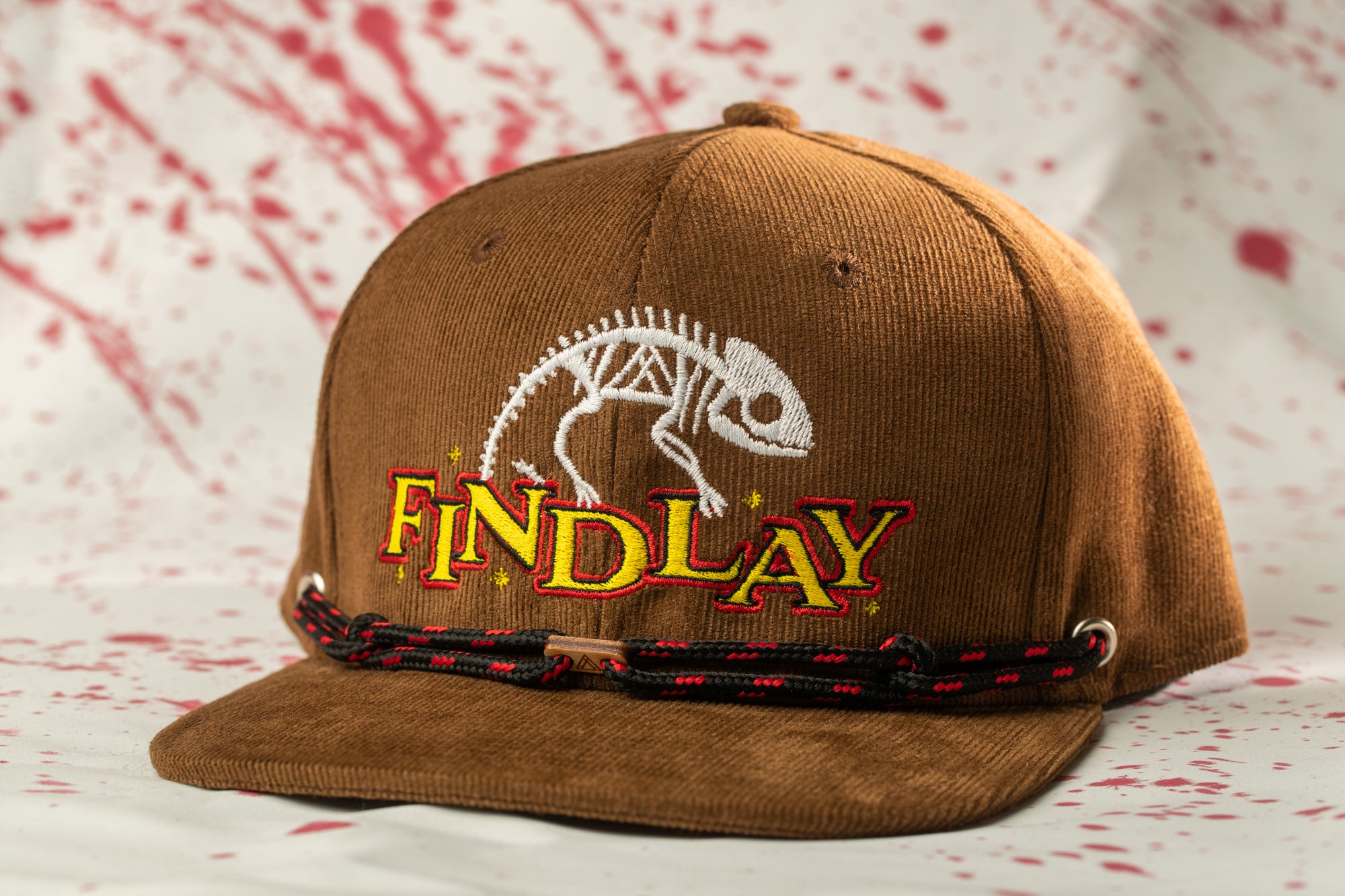 A brown baseball cap with a white and yellow logo and the word "FINDlay" printed on it.