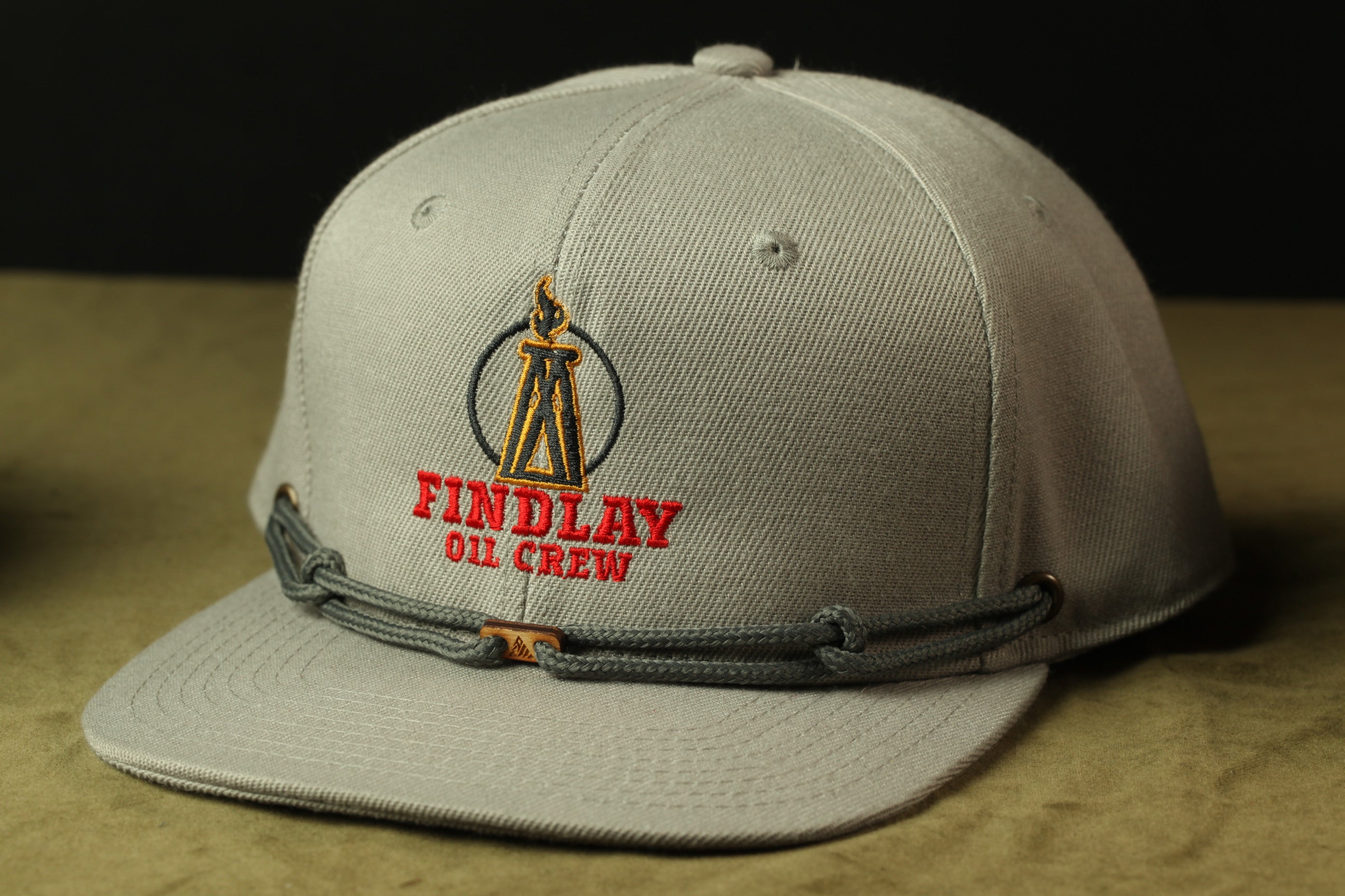 A gray baseball cap with a logo and text on it.
