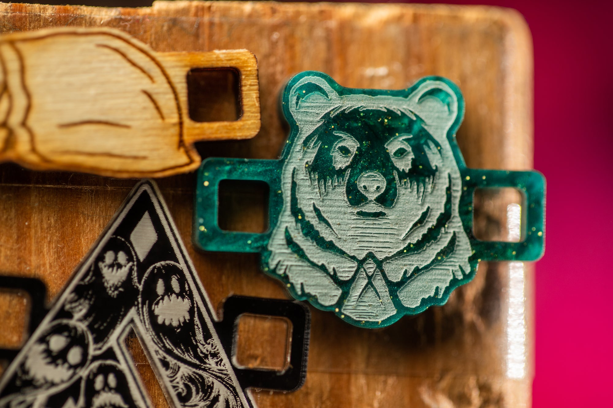 a close-up of a green bear-shaped object with a tie, placed on a wooden surface.