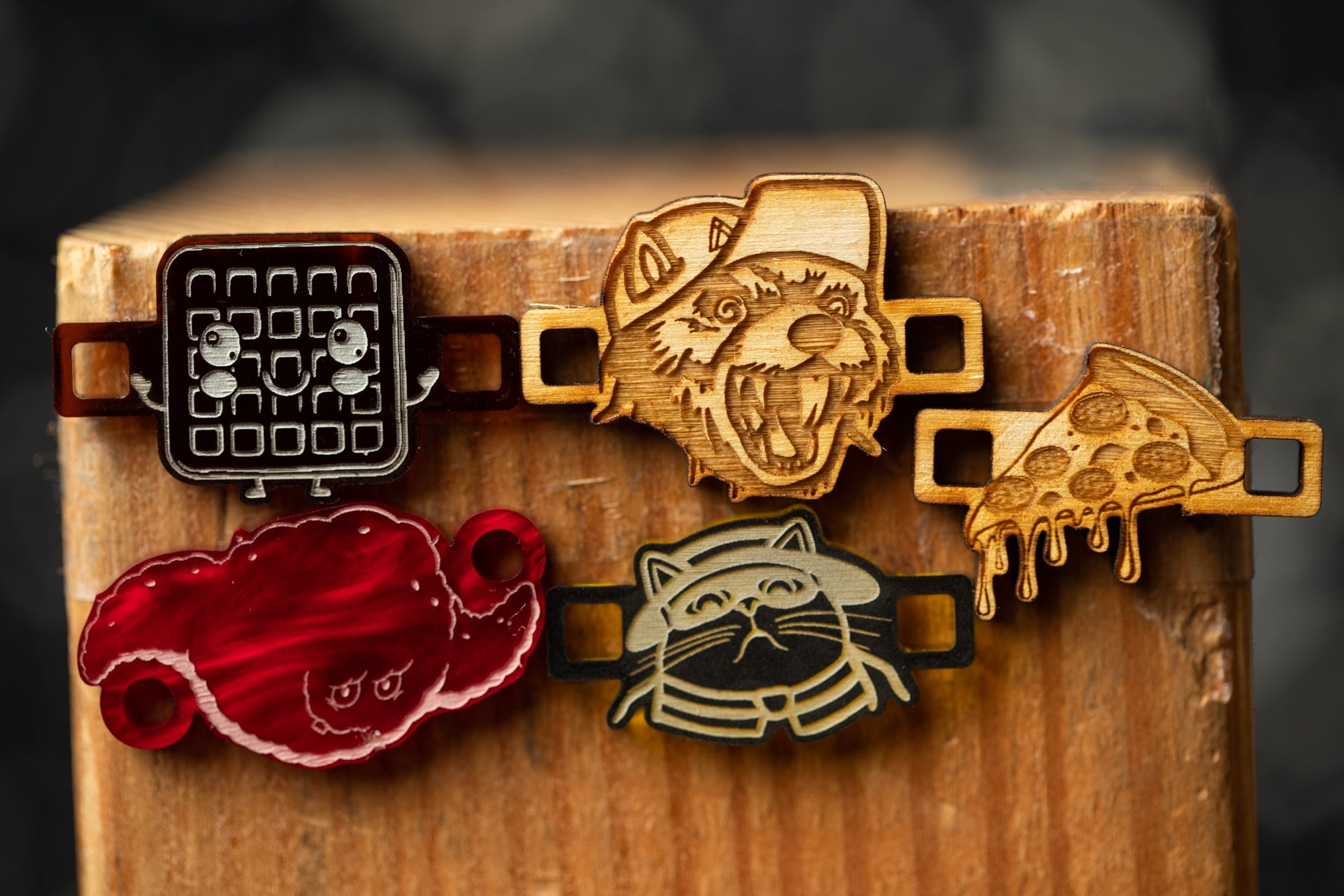 a wooden surface with various wooden objects, including a waffle, a cat, a dog, and a slice of pizza, each with a unique design or shape.