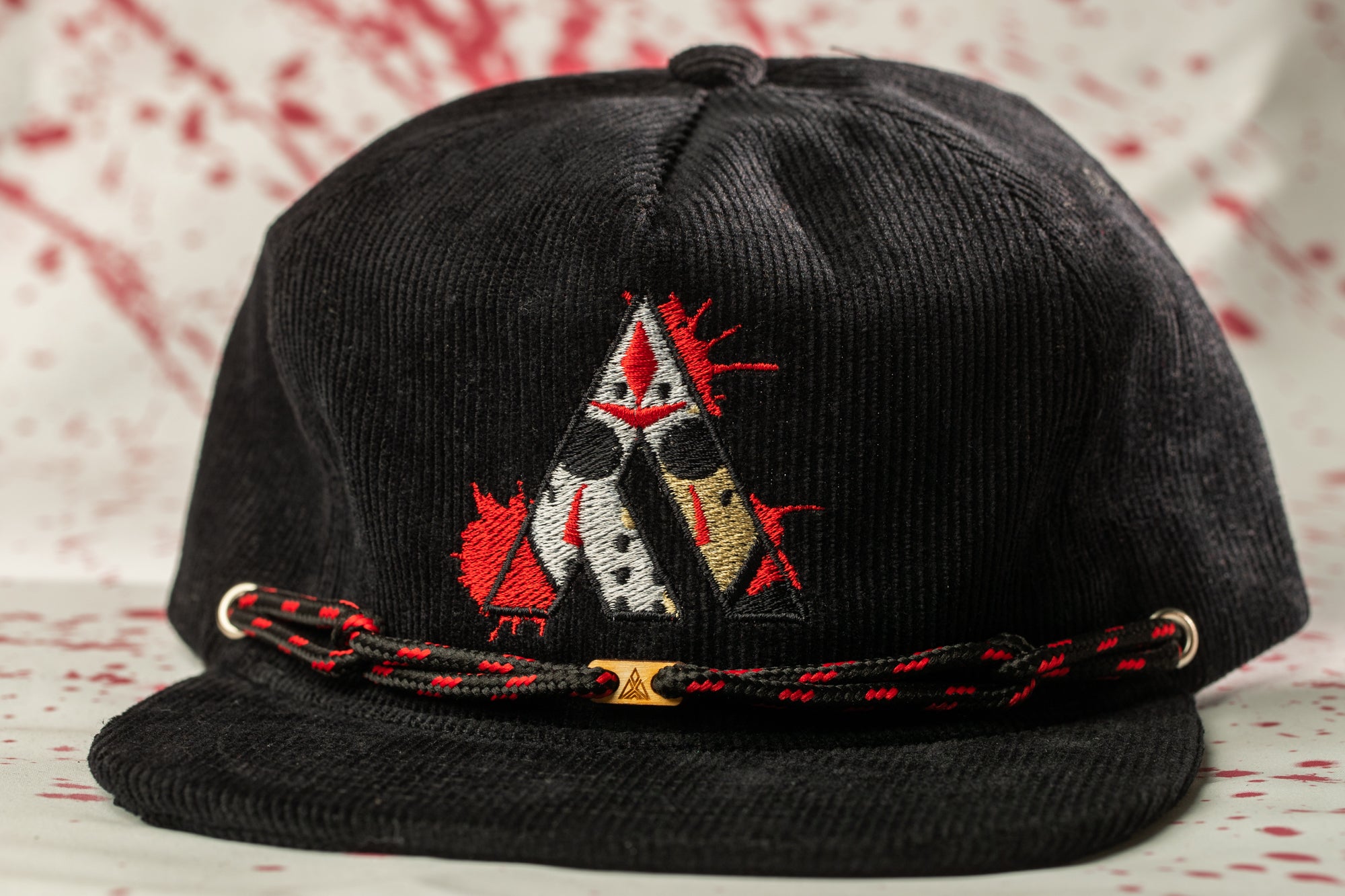 A black baseball cap with a red and white embroidered design on the front.