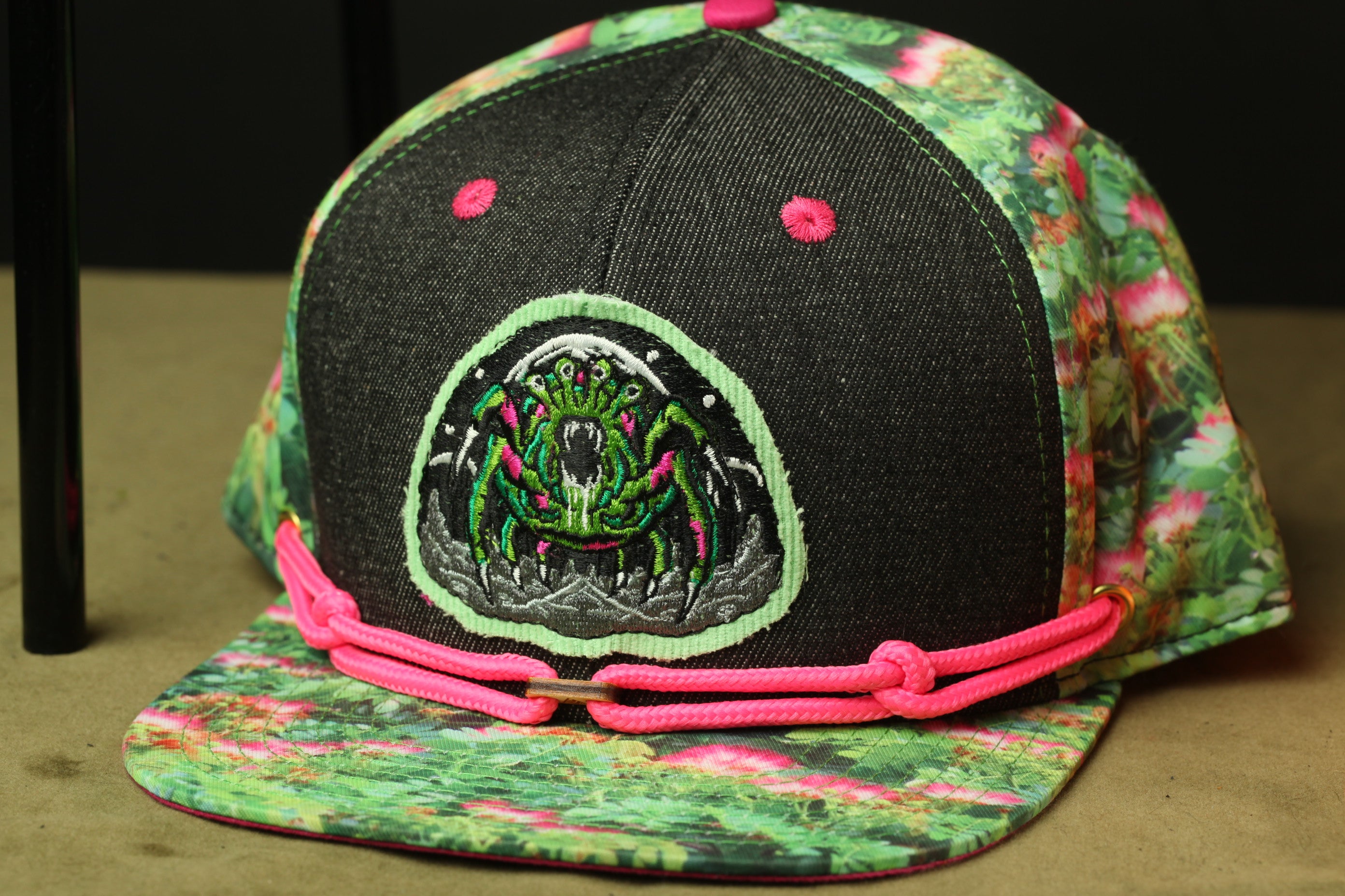 A colorful baseball cap with a floral pattern and a prominent embroidered design on the front.