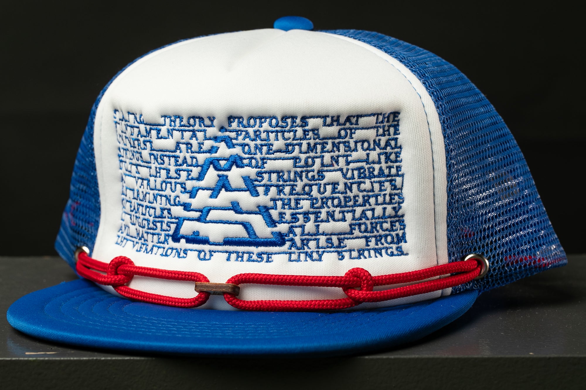 A blue and white baseball cap with a mesh back and a red chain strap.