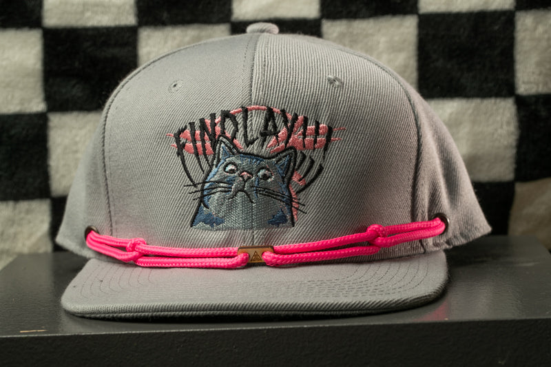 A gray baseball cap with a cat embroidered on it, wearing a pink string or strap.