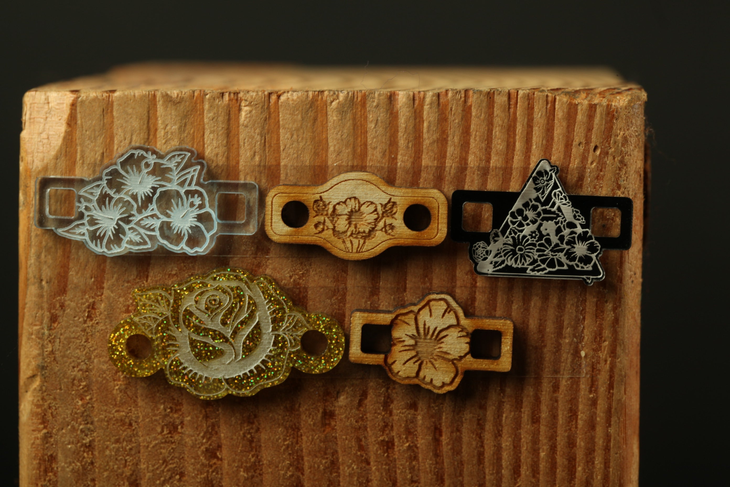 a collection of five different wooden objects, each with unique designs and patterns, arranged on a wooden surface.