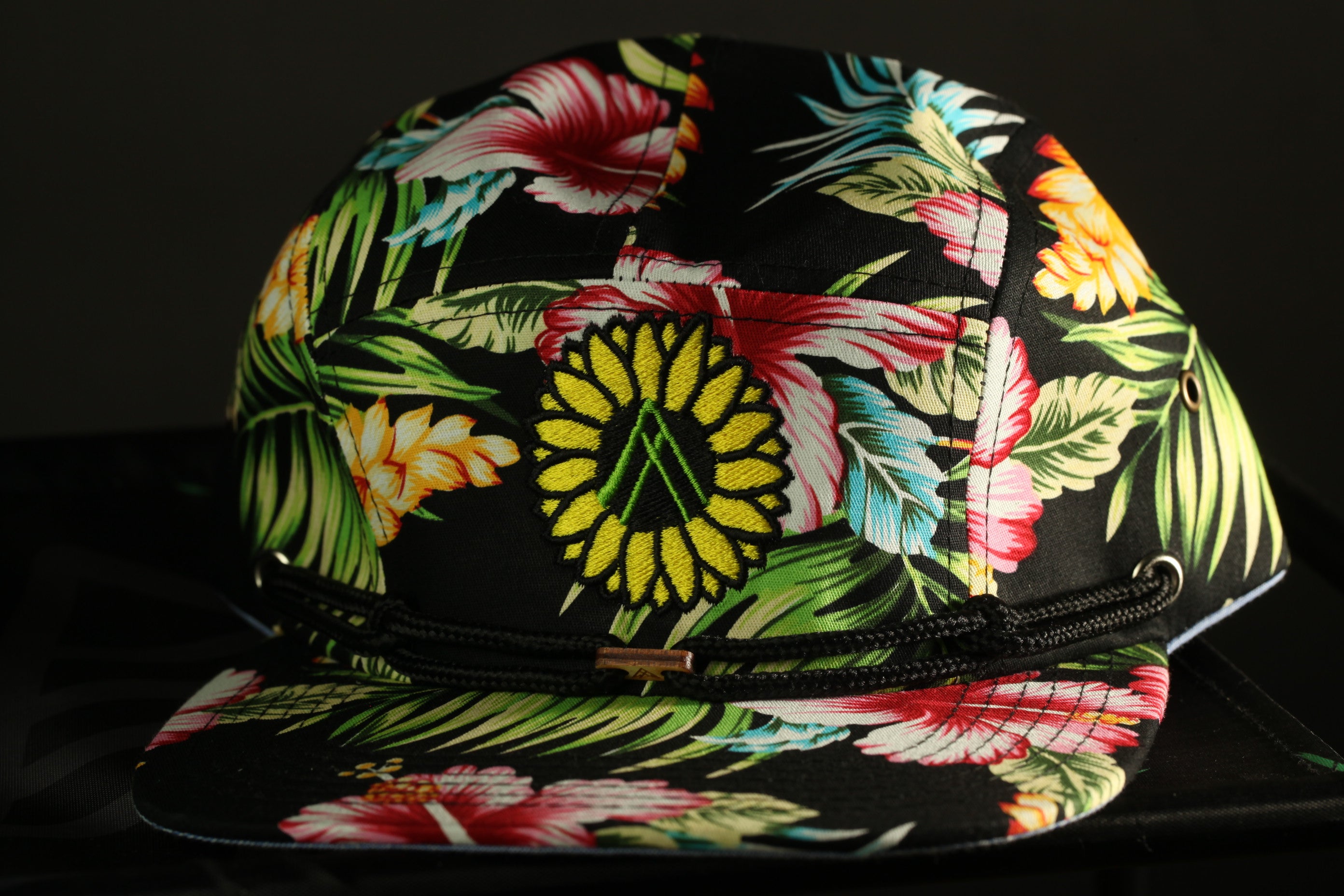 A colorful floral print cap with a yellow sunflower design.