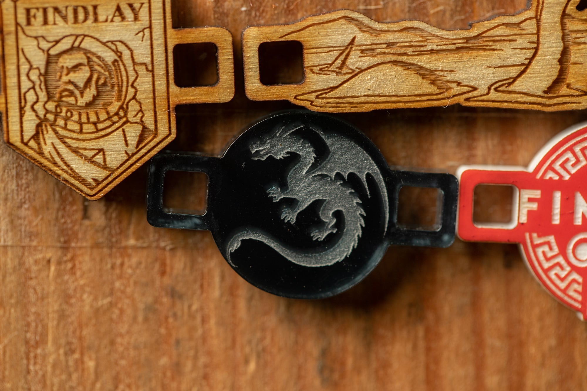 a close-up view of a wooden surface with various engraved and printed objects, including a dragon emblem and a wooden shield with a shield-like design.