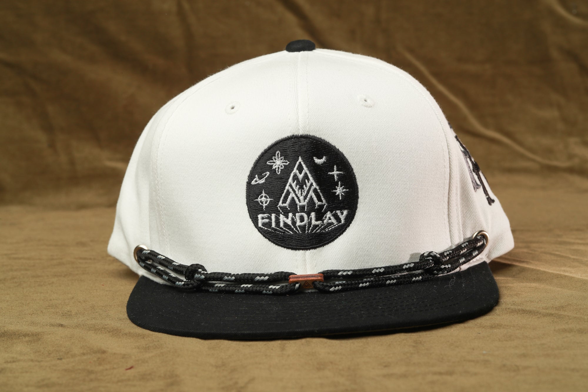 A white baseball cap with a black brim and a black and white logo on the front.