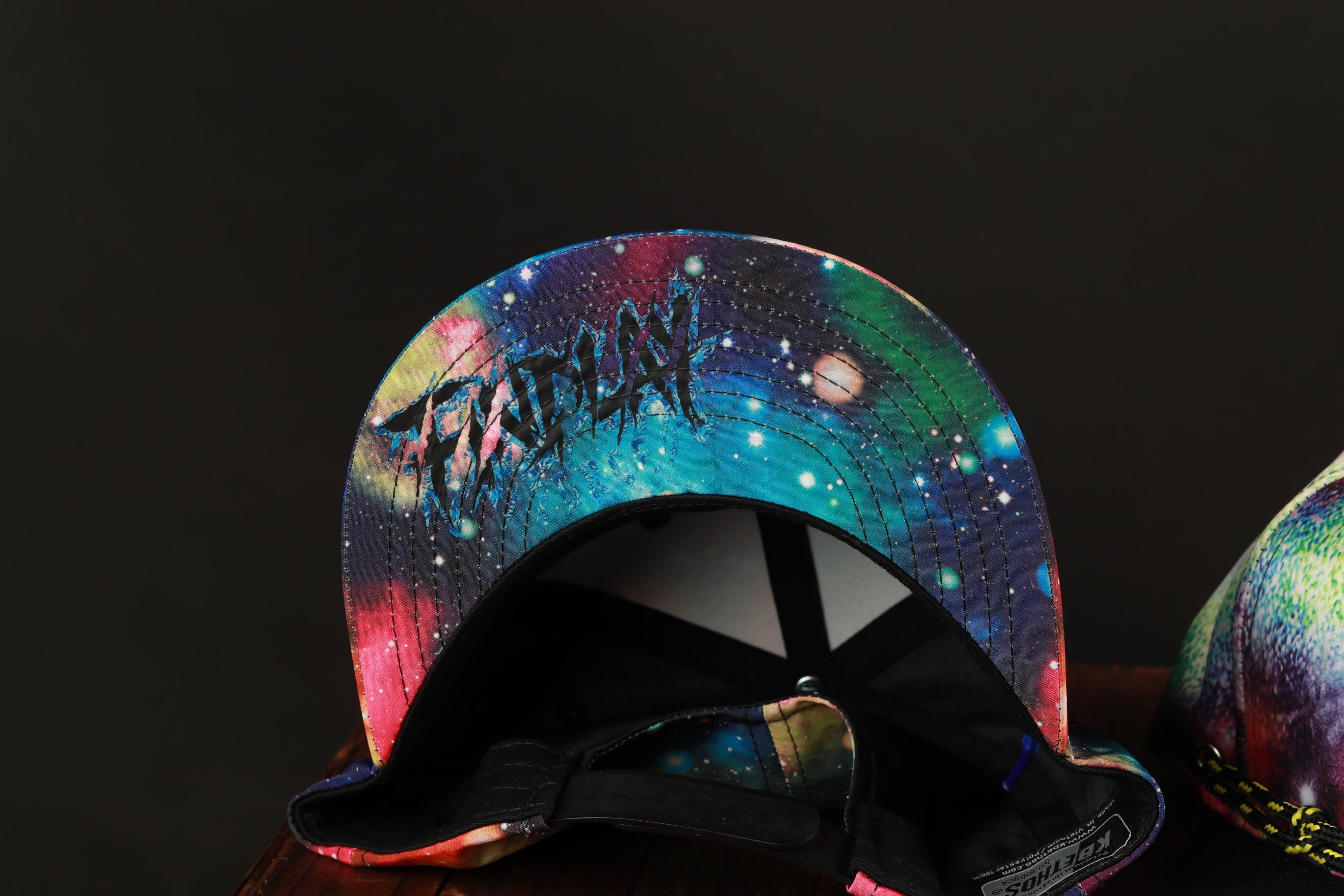 A colorful, patterned baseball cap with a galaxy-themed design.