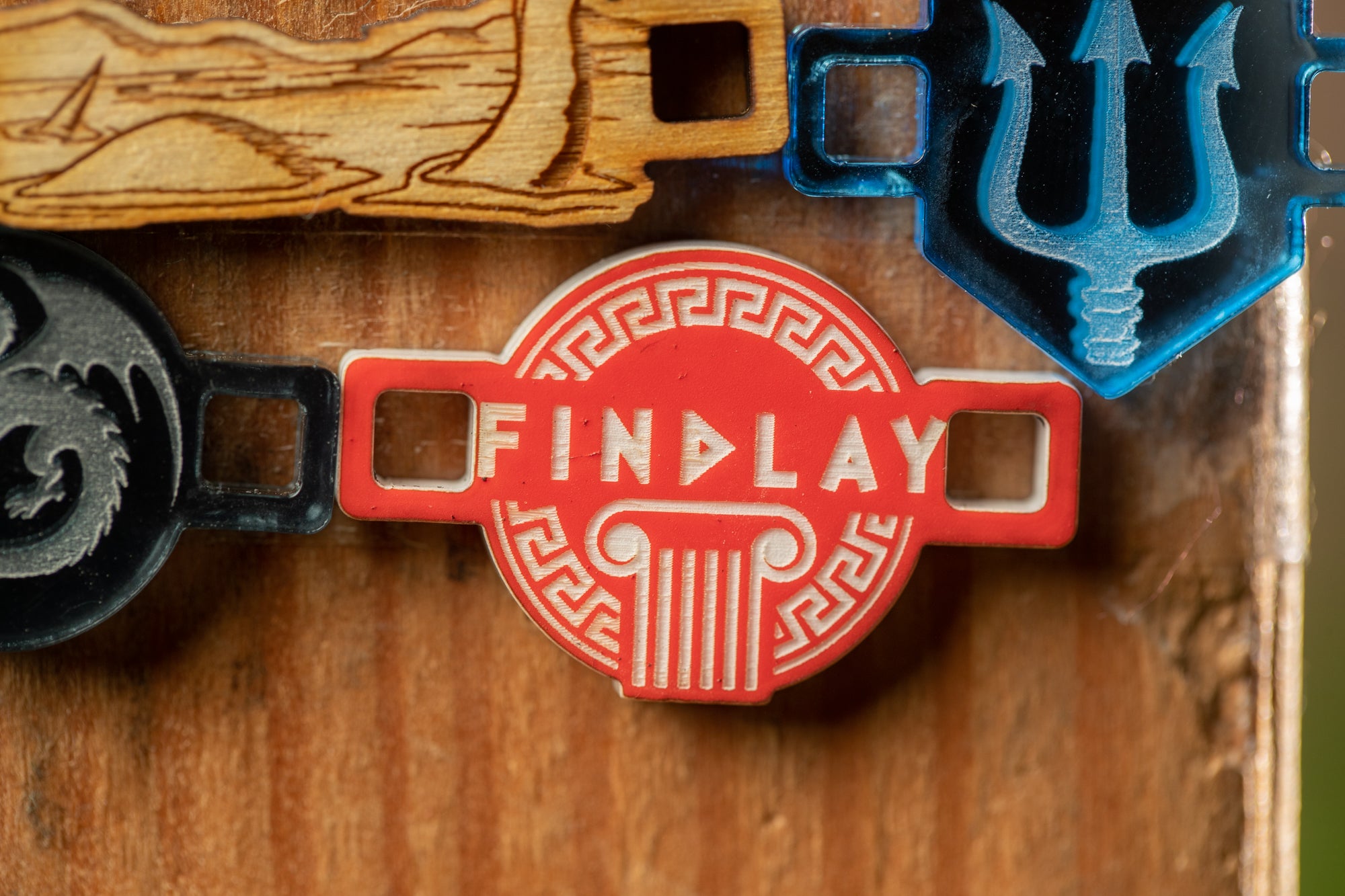 a close-up of a red and white logo with the text "FIND LAY" on it, surrounded by various other logos and designs.