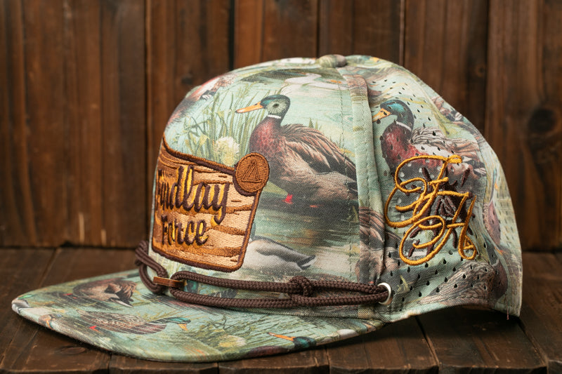 A printed baseball cap with a camouflage pattern and various bird illustrations, including ducks and geese.