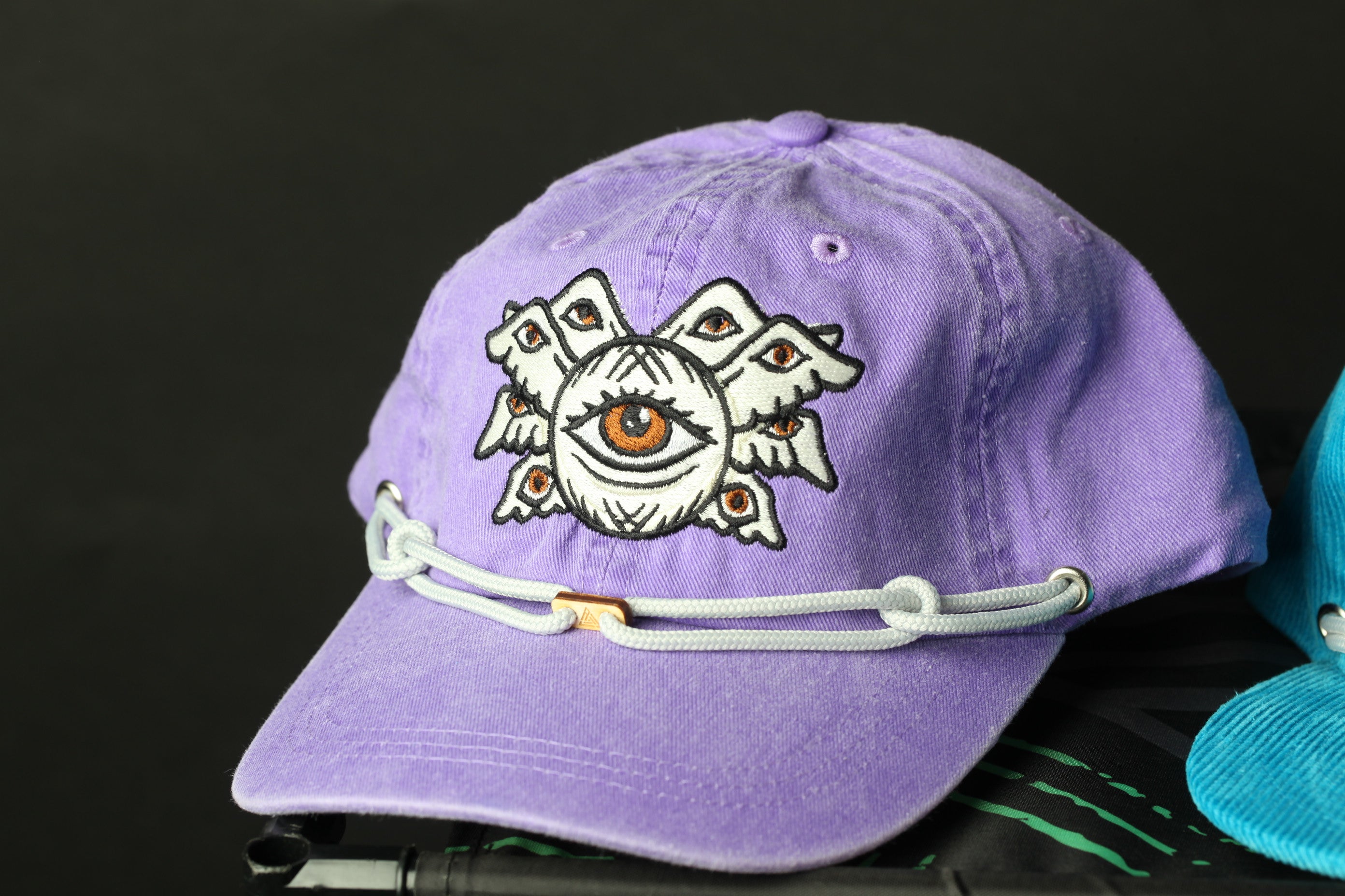 A purple baseball cap with an eye design on it.