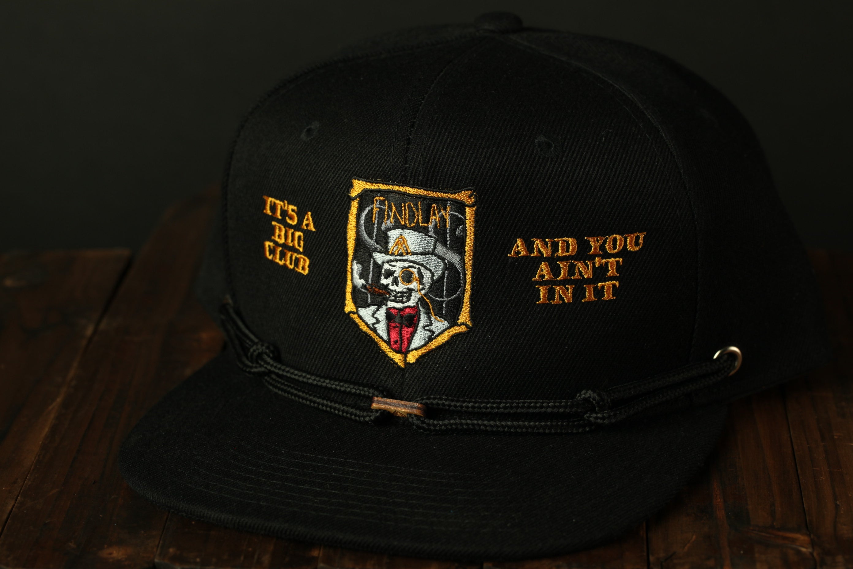 A black baseball cap with a skull and crossbones design, and text on the front.