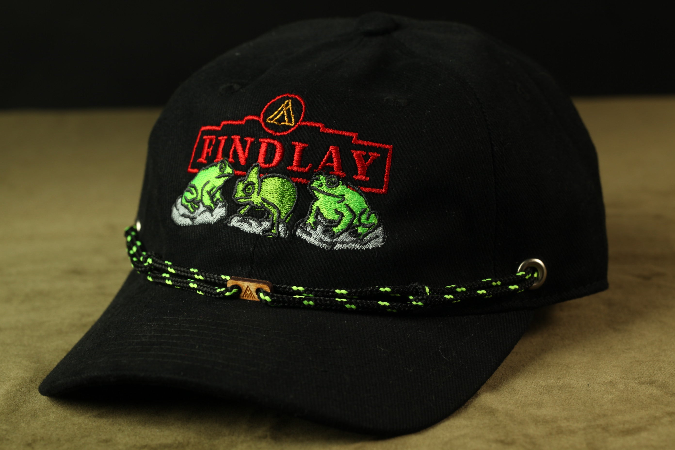 A black baseball cap with a red and green embroidered logo on the front.