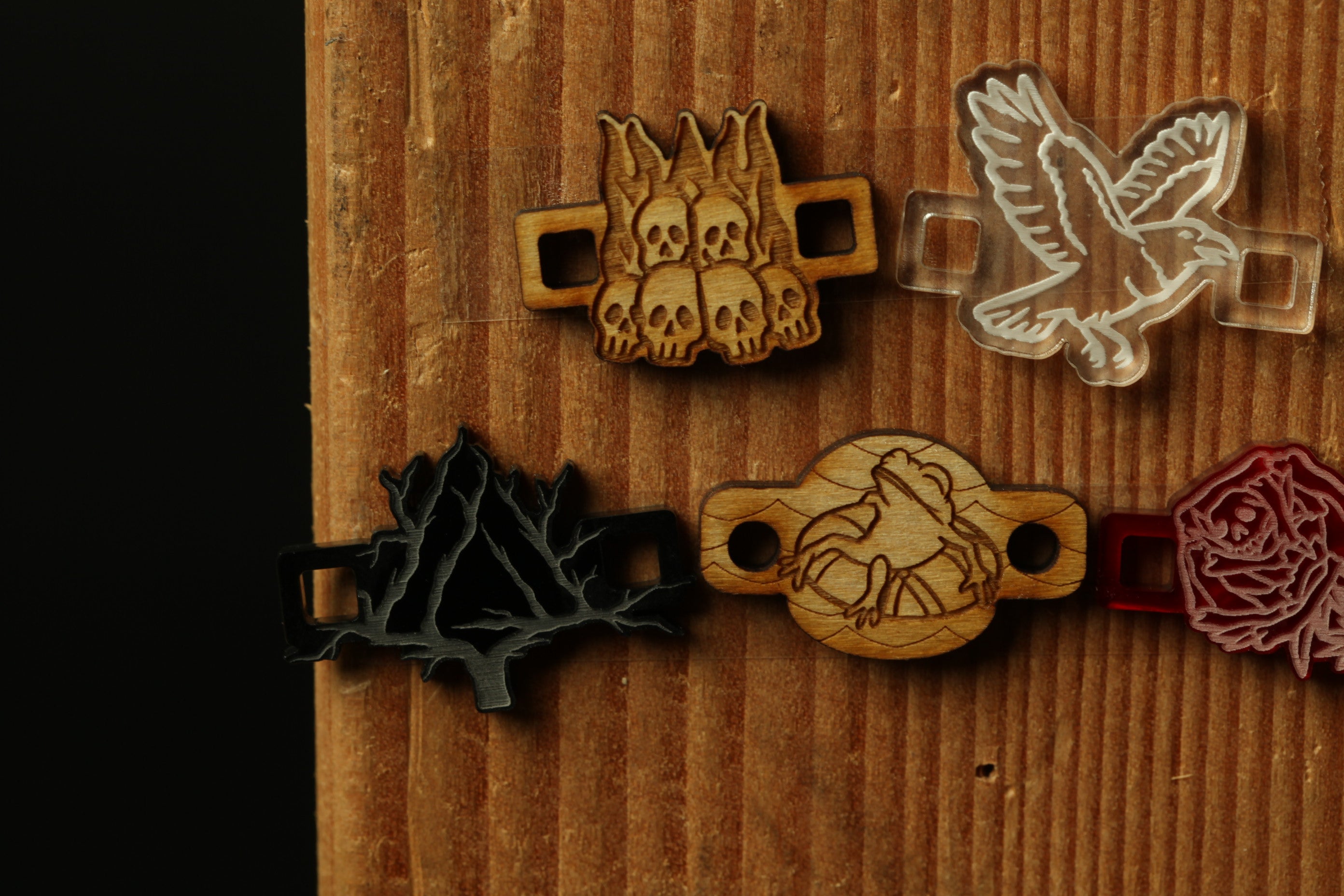 a collection of wooden and plastic objects, including a wooden bird, a wooden skull, and a plastic rose, all displayed on a wooden surface.