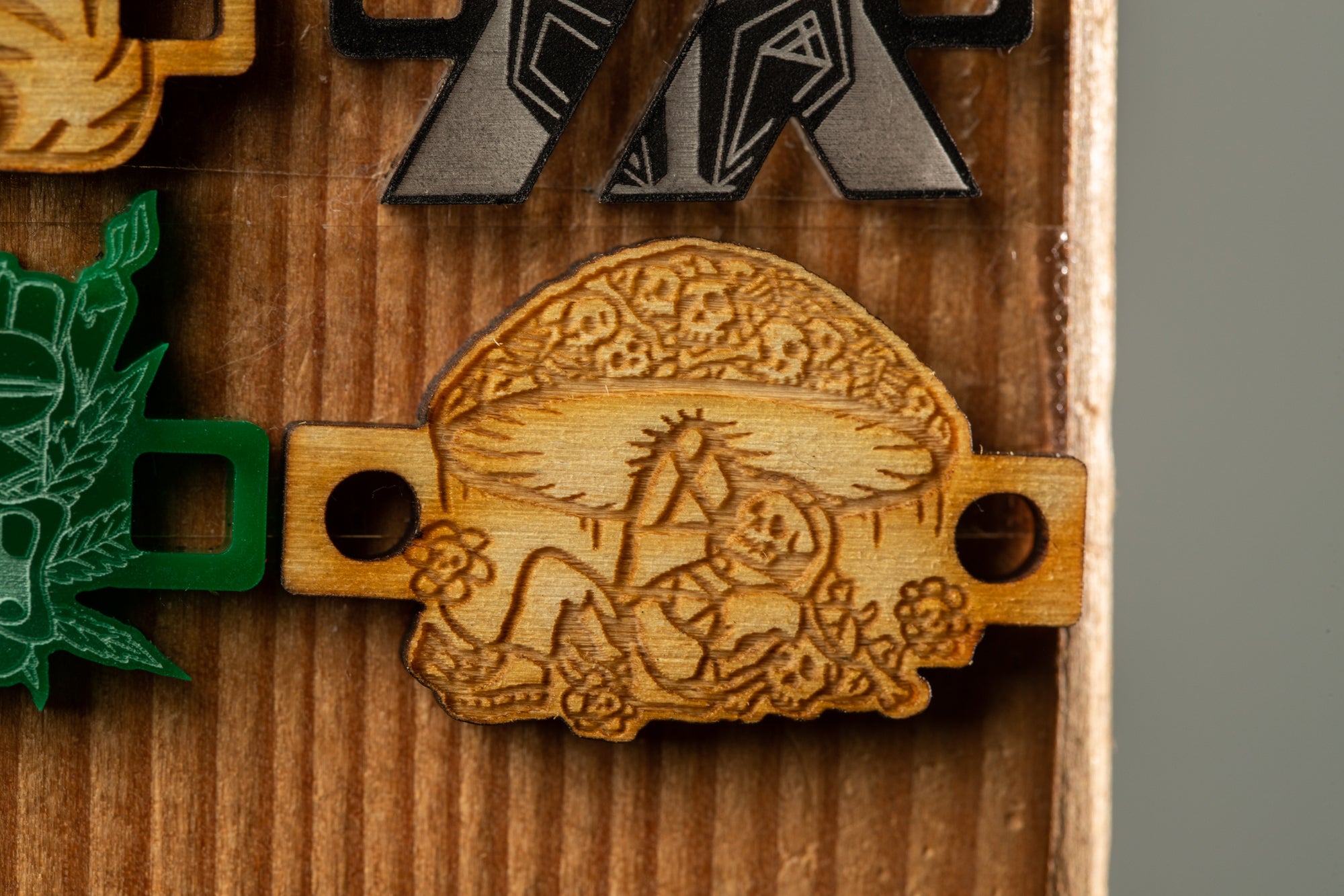 a wooden object with an intricate carved design, including a mushroom-like shape with a skull and floral motif.