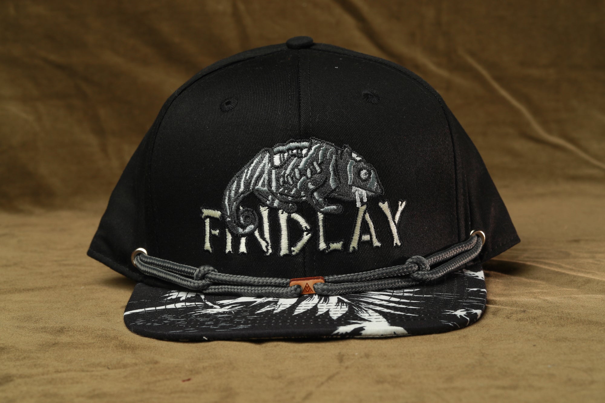 A black baseball cap with a graphic of a chameleon and the word "FINDlay" printed on it.